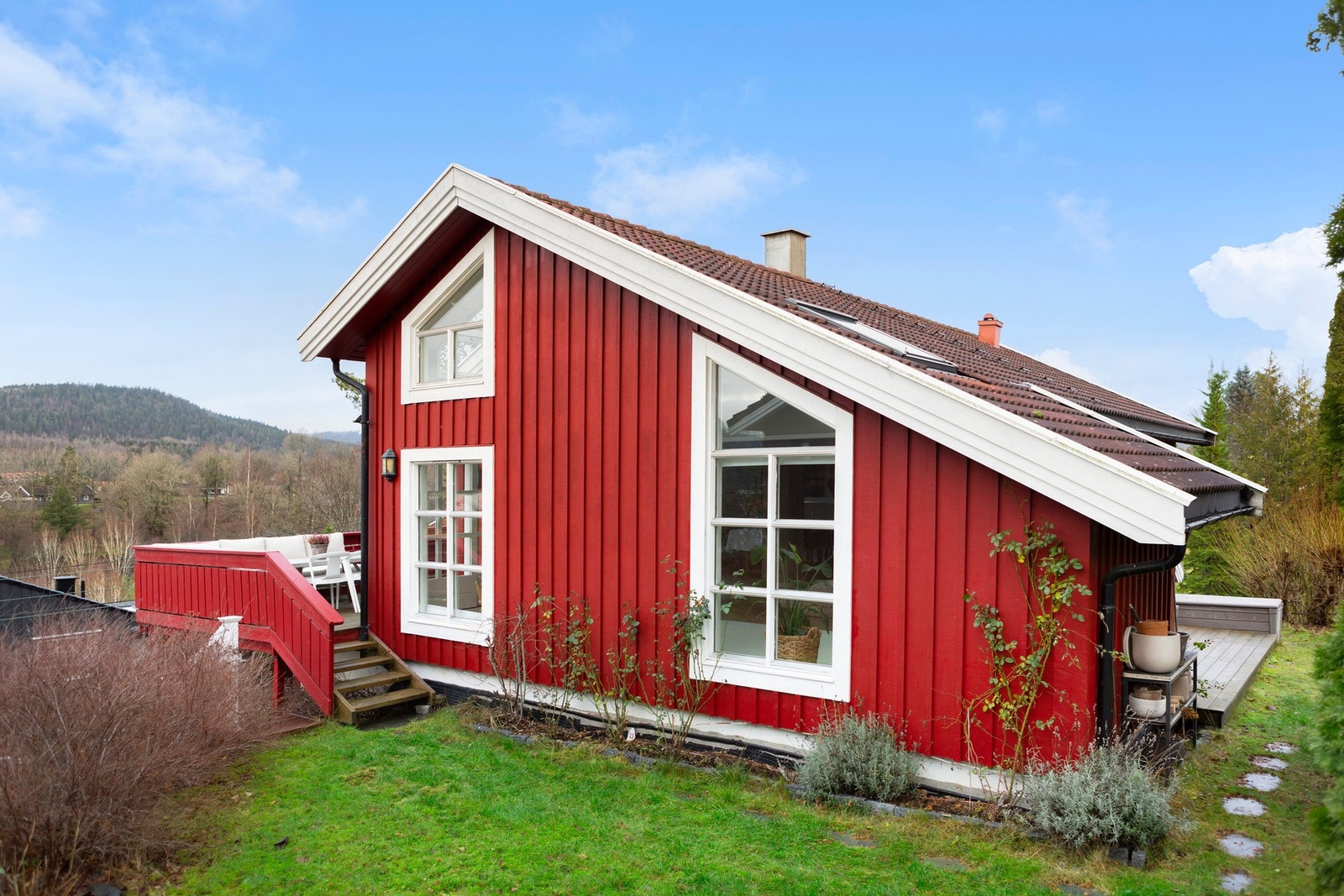 Sjarmerende og velholdt fasade med store vindusflater og direkte adkomst til solrike uteområder- et trivelig hjem med hyggelige uteområder. Galleribilde