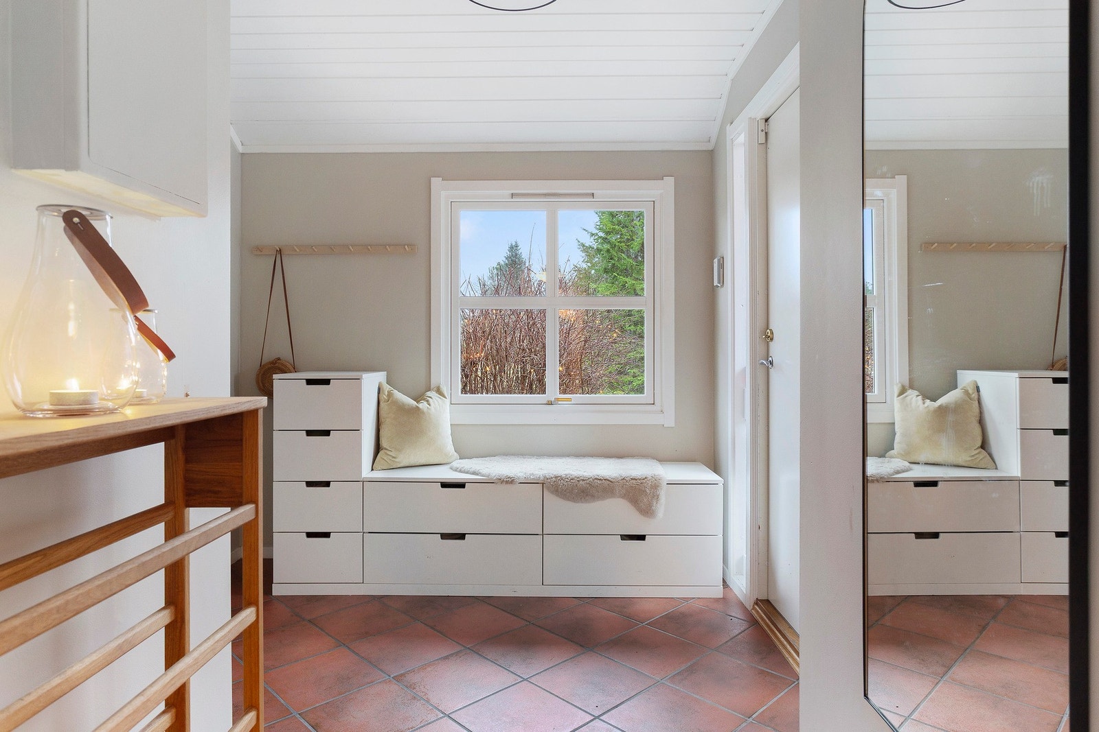 Lys og innbydende entré med praktisk sittebenk og smart oppbevaring - et hyggelig førsteinntrykk av hjemmet. Galleribilde