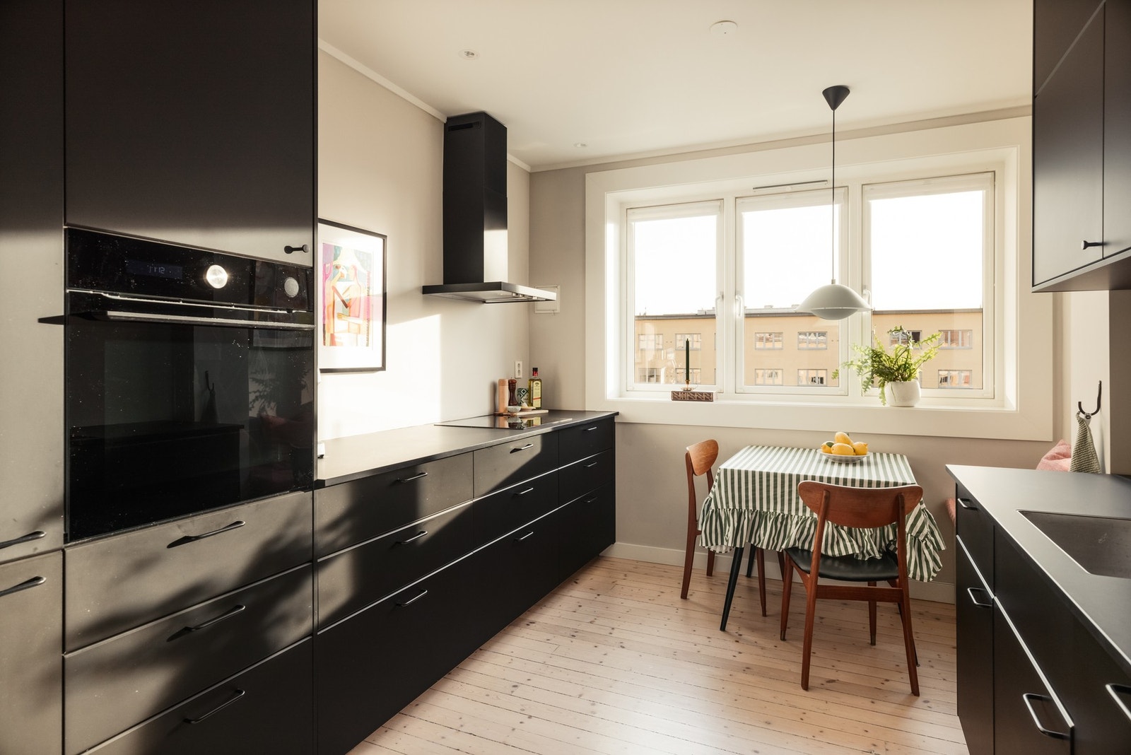 Kjøkkenet er virkelig leilighetens hjerterom - her er det nydelig innredning i sorte, glatte fronter. Galleribilde
