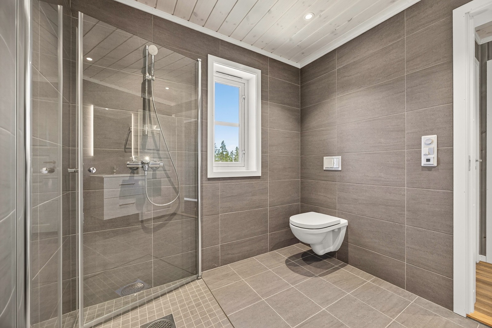 Badet har vegghengt toalett og innsvingbare dusjvegger i herdet glass. Bildet er ikke av selve hytta. Galleribilde