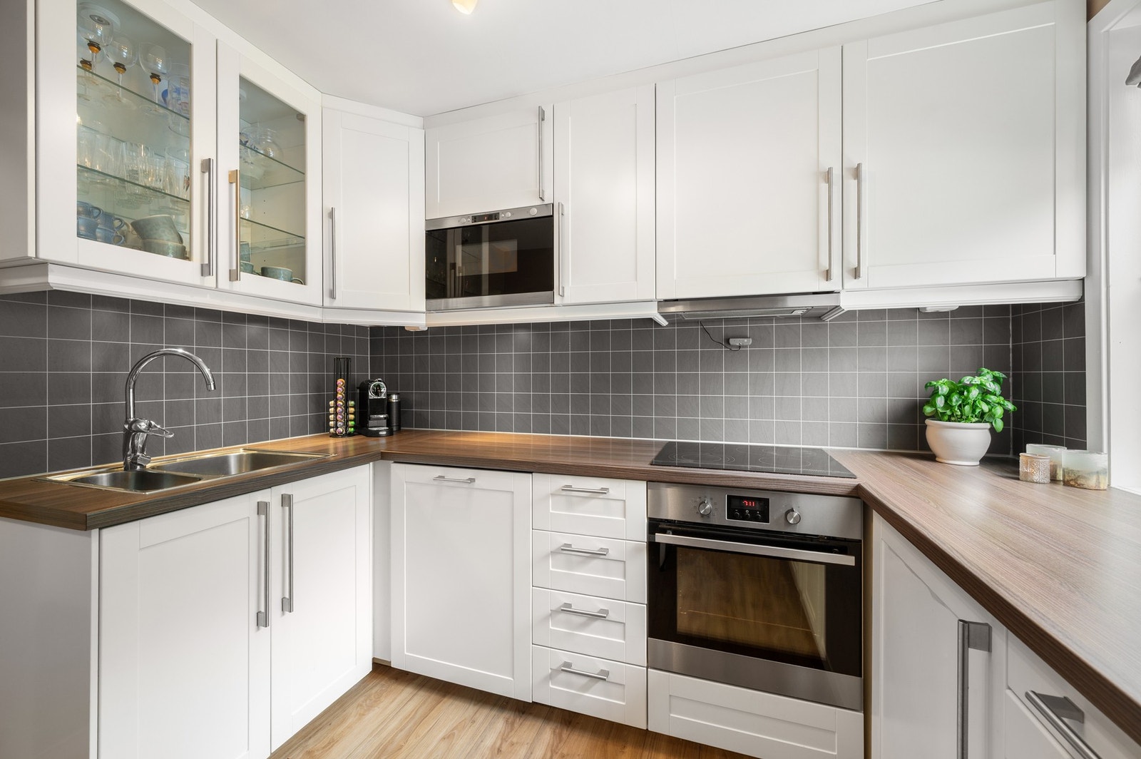 Lyst og pent kjøkken med integrerte hvitevarer og godt med skap- og benkeplass. Galleribilde