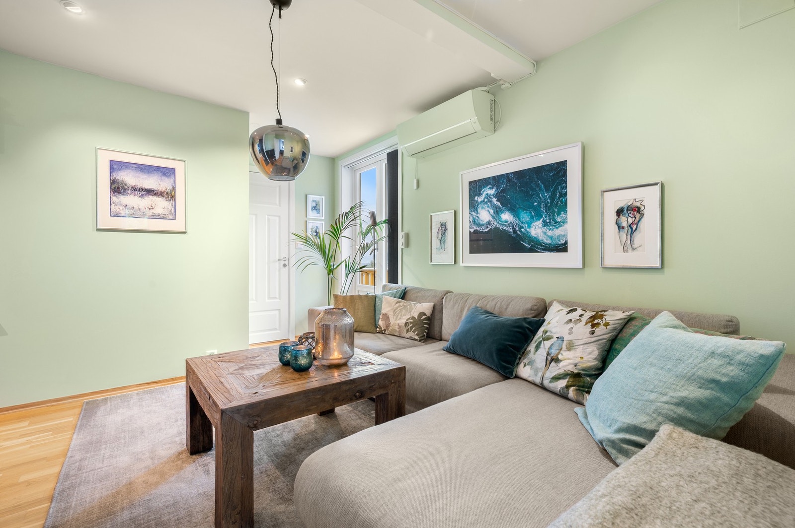 Stuen er malt i lyse og friske farger, noe som gir rommet et moderne og innbydende preg. Galleribilde