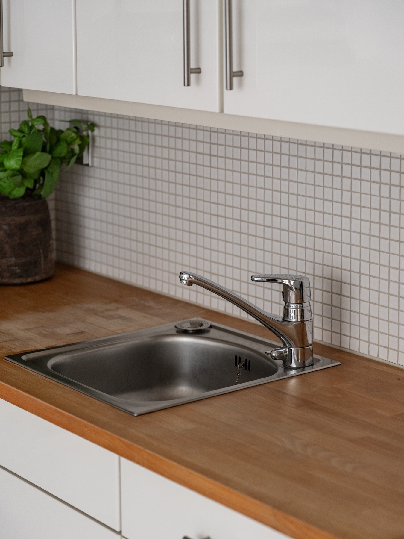 Heltre benkeplate med nedfelt oppvaskkum, samt lekre fliser mellom benk og overskap Galleribilde