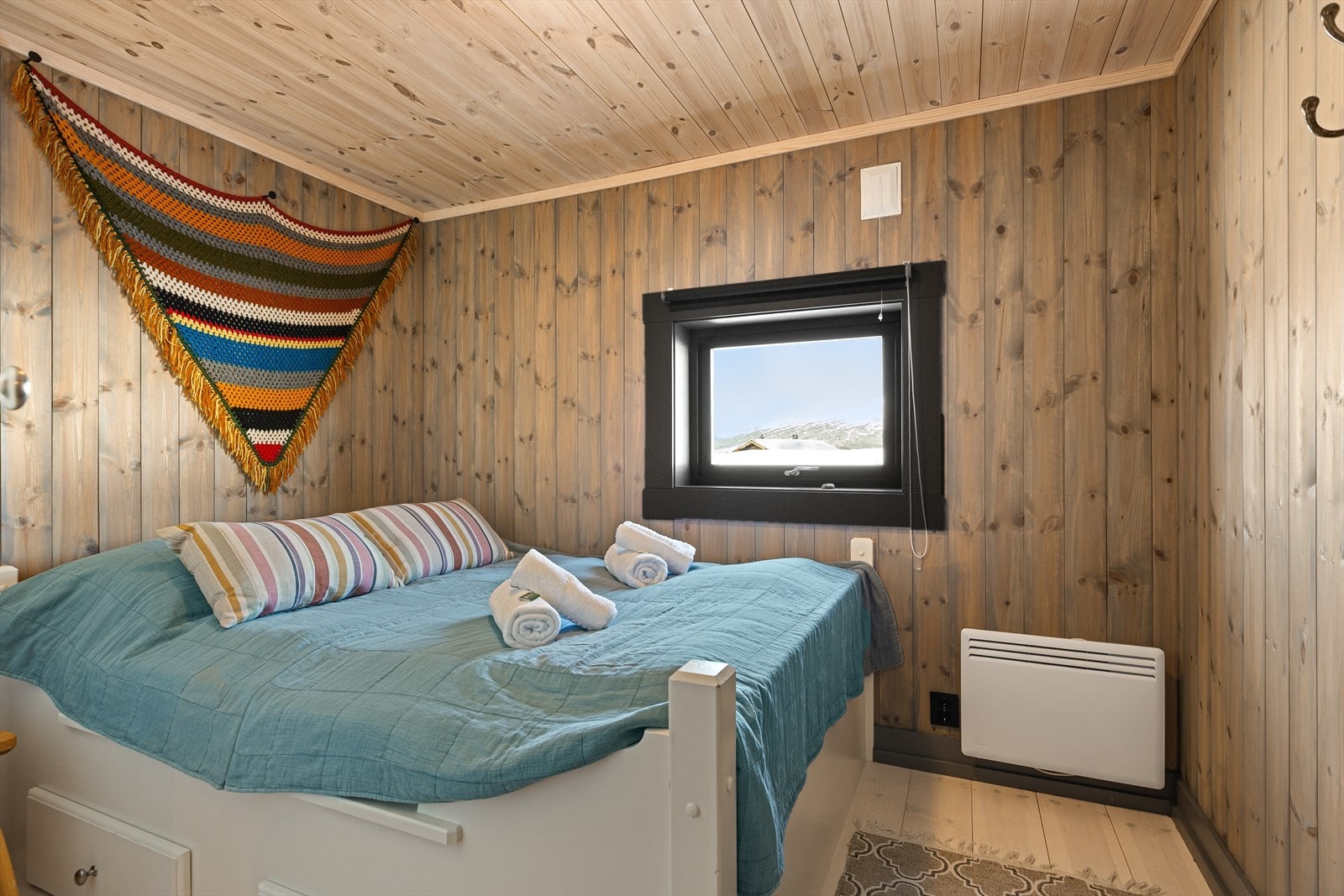 I hytta er det tre soverom, alle med pene heltre senger og tilhørende garderobeskap. På hovedsoverommet er det dobbelteseng med praktiske oppbevaringsskuffer i sokkel. Galleribilde