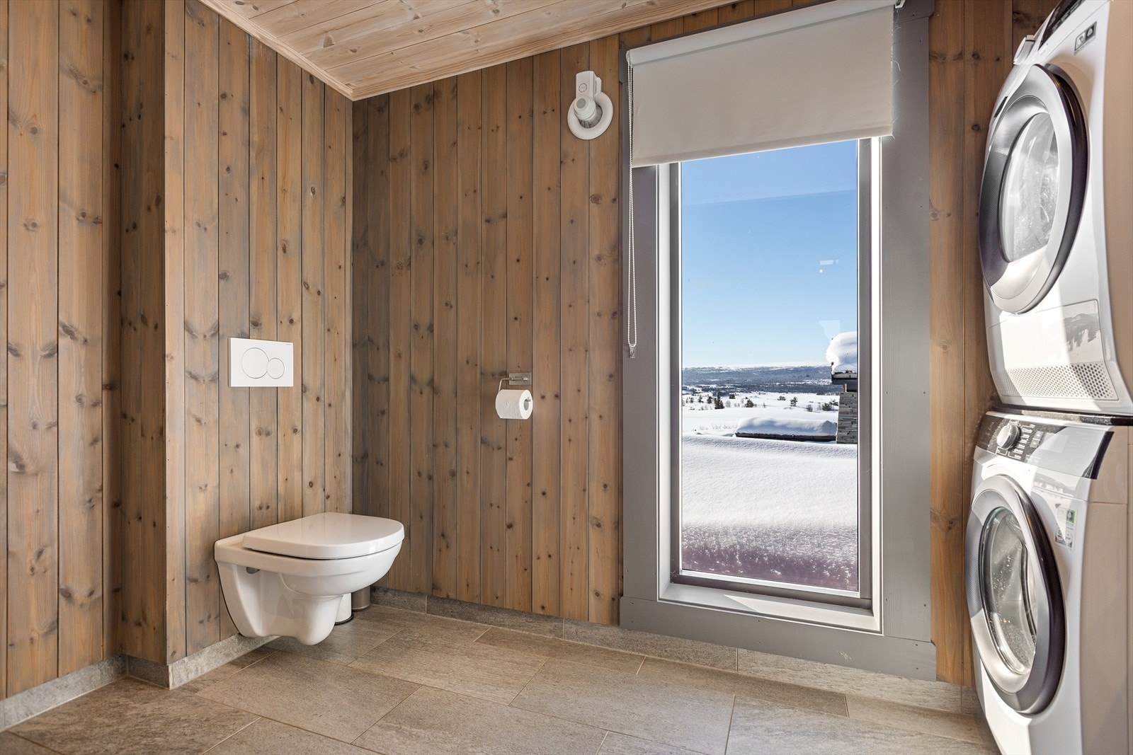 På badet er det veggehengt toalett med innebygd sisterne, samt opplegg for vaskemaskin og tørketrommel. Elektrisk styrt vifte i yttervegg. Galleribilde