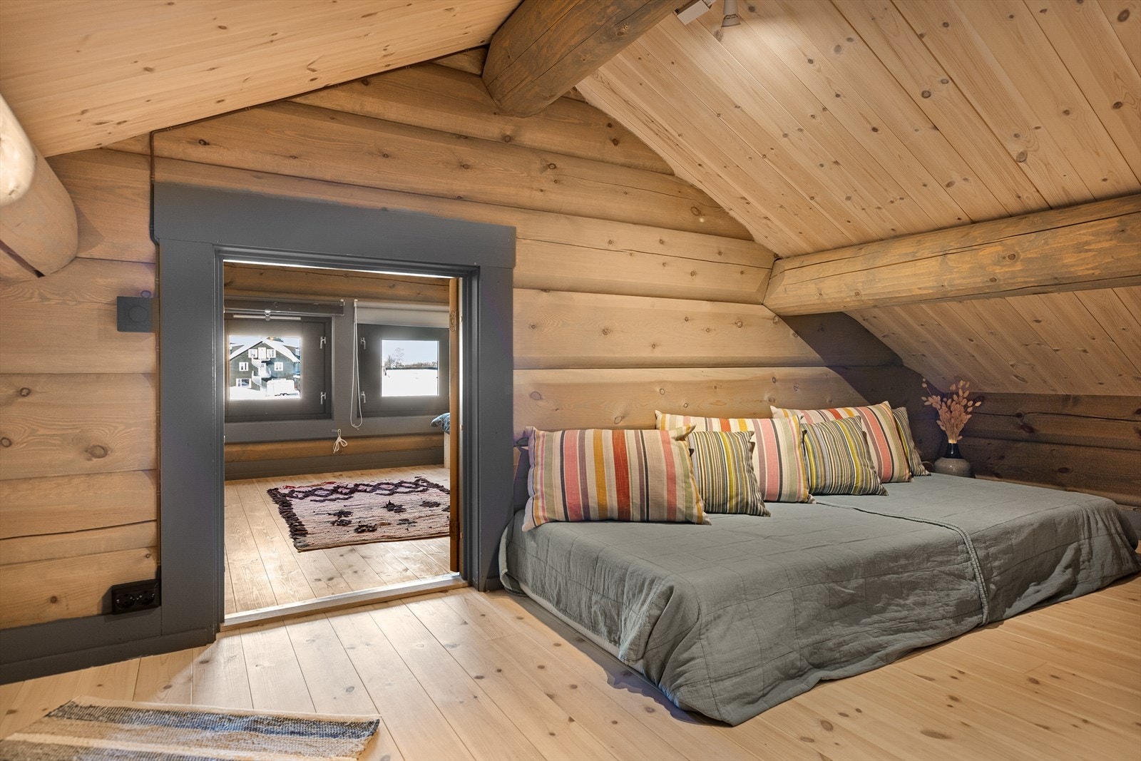 Rommene oppe på hemsen har tømmervegger og flotte tømmeråser, noe som er gjennomgående i hele hytta. Galleribilde