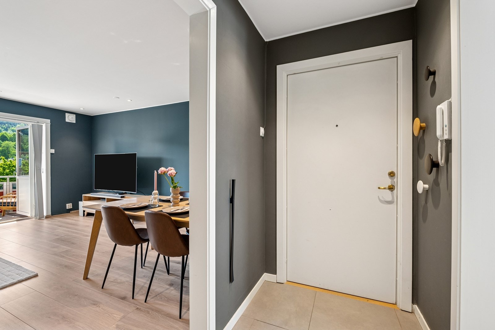 Gang med flislagt gulv samt callinganlegg på veggen. Galleribilde