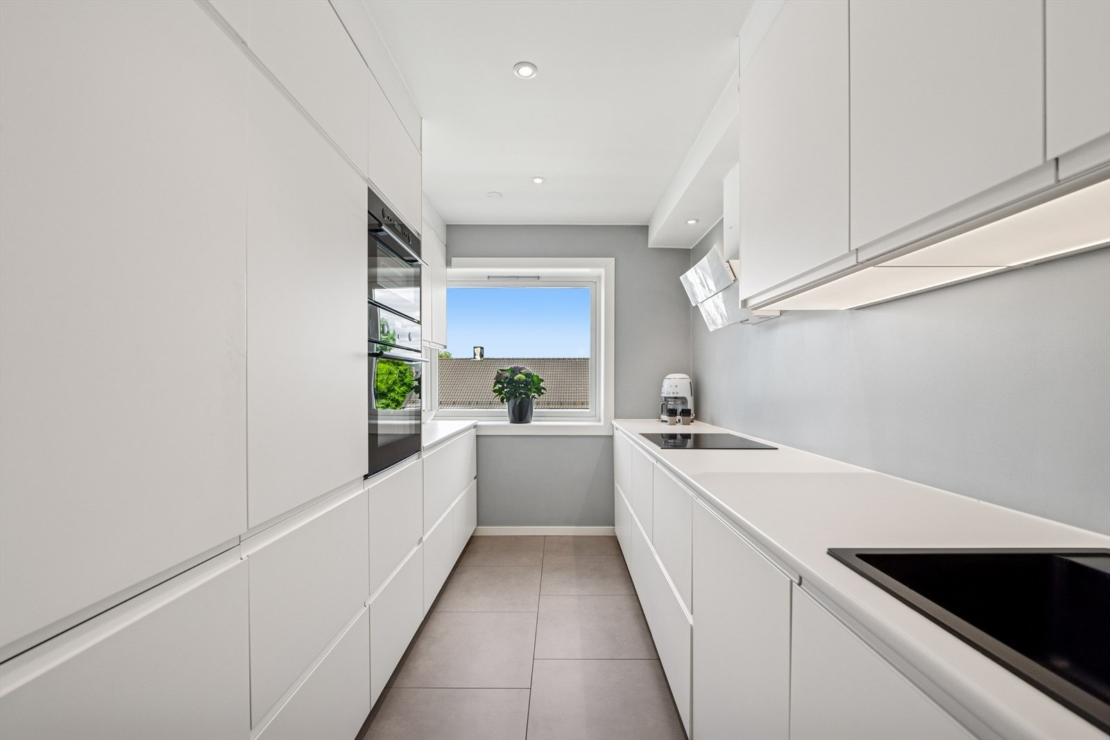 Kjøkkenet er innredet med slette fronter og benkeplaten er av laminat. Galleribilde