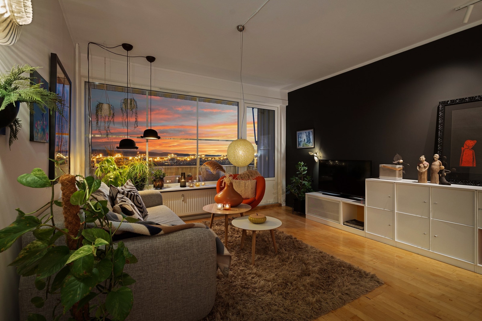 Hvitmalte flater med en mørk fondvegg som gir et moderne uttrykk, og på gulvet er det lys bjørkeparkett Galleribilde