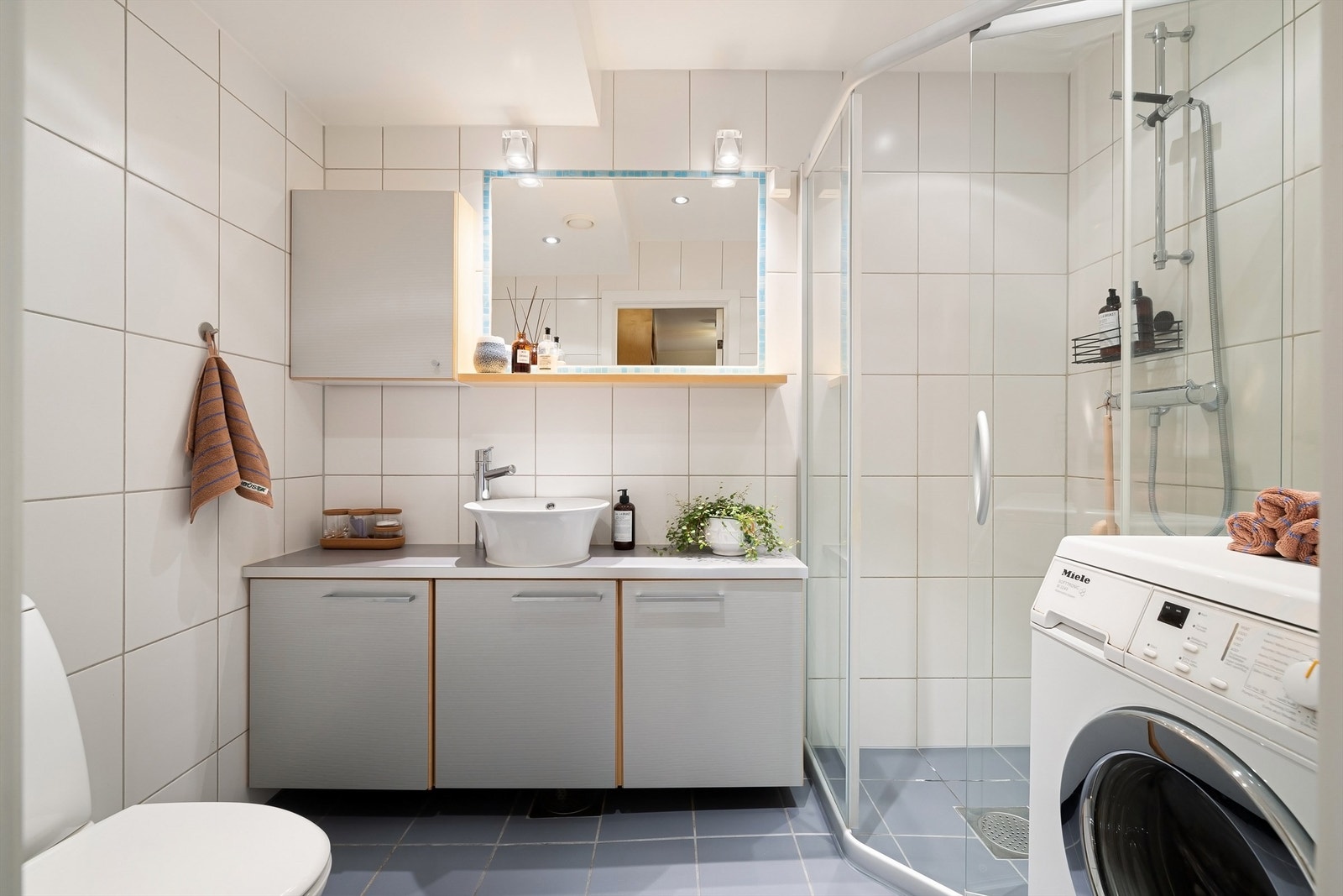 Pent, flislagt bad med gulvvarme, samt opplegg for både vaskemaskin og tørketrommel Galleribilde