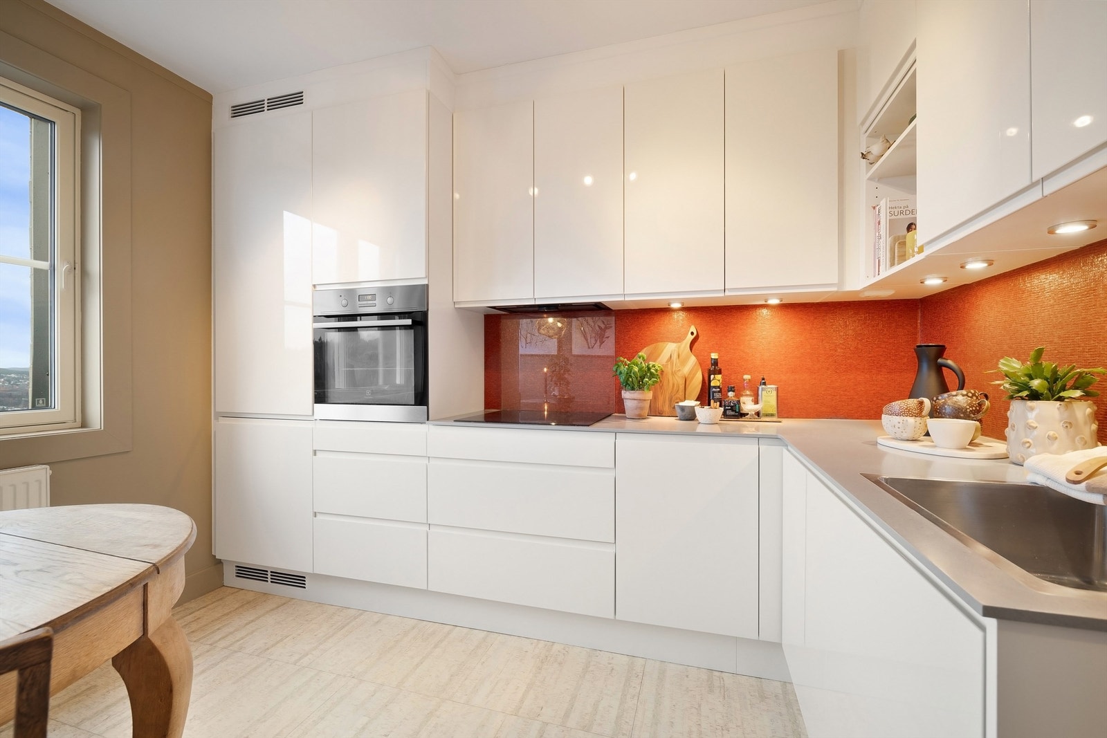 Integrerte hvitevarer som stekeovn, koketopp med kullfilterventilator over, oppvaskmaskin og kjøleskap med frysedel Galleribilde