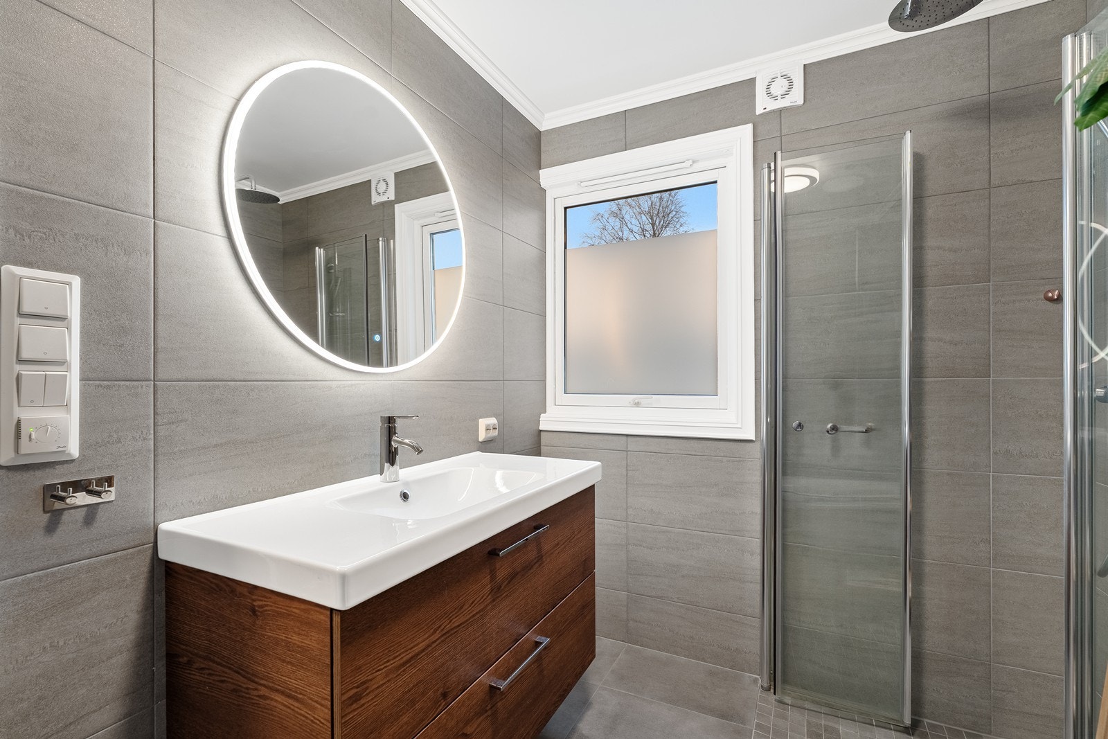 Delikat baderom i andre etasje. Store mørke fliser og pen baderomsinnredning. Galleribilde