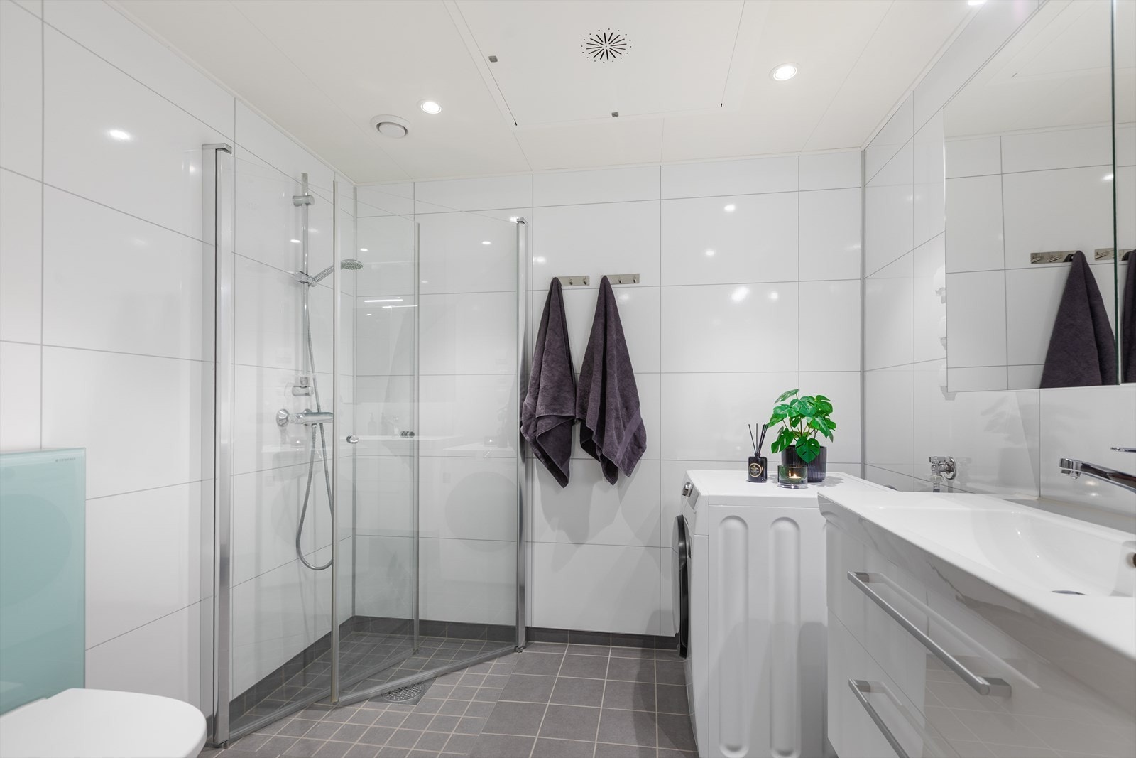 Innbydende bad fra byggeår med mørke gulvfliser og hvite baderomsplater på veggene. Galleribilde