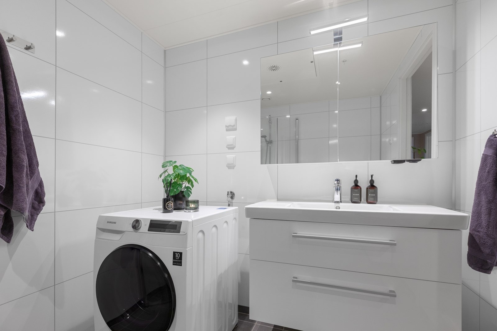 Badet har opplegg for vaskemaskin og tørketrommel, samt servantskap med belyst speil. Galleribilde