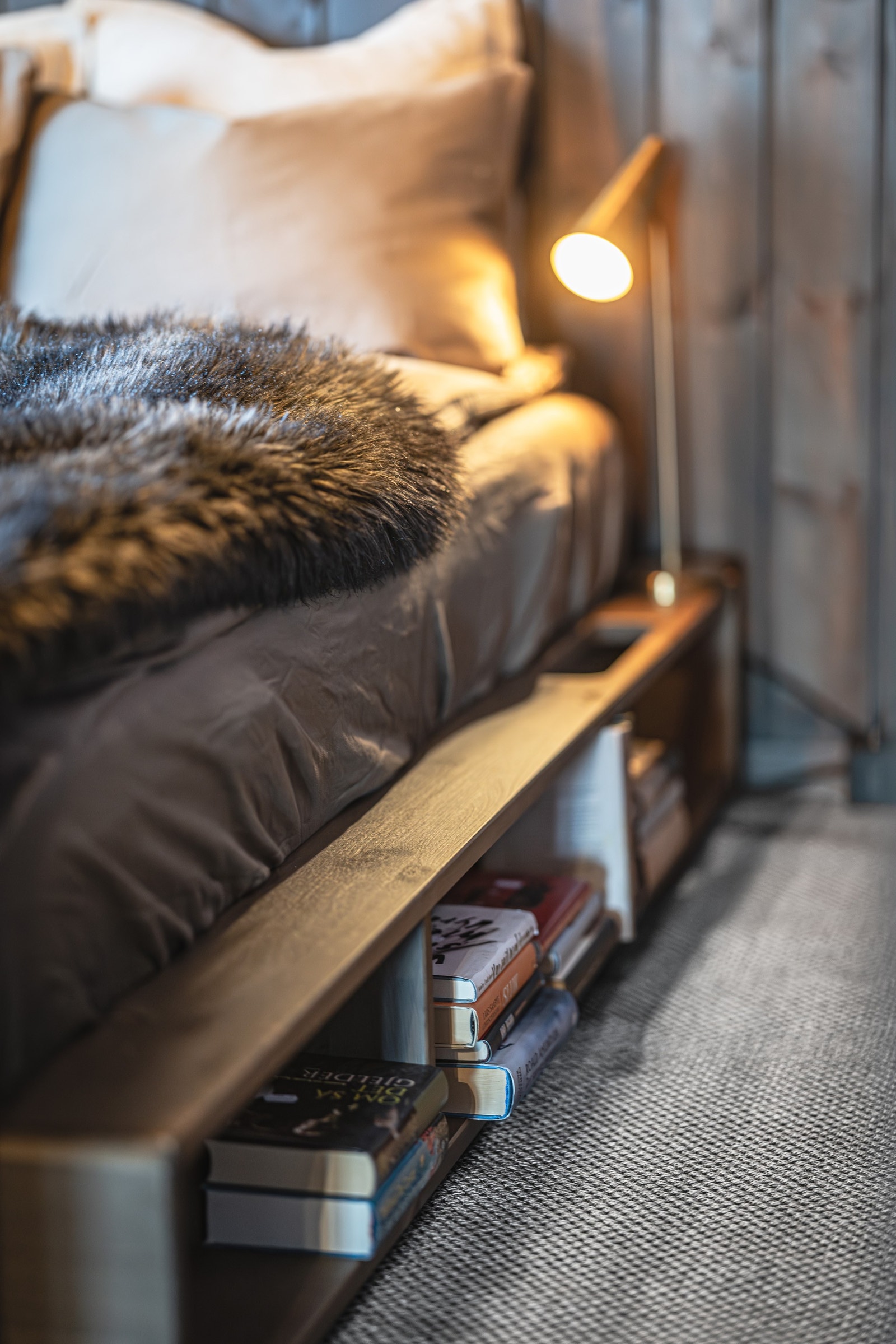 Seng fra Karup Design – praktisk og kul løsning med integrert bokhylle. Vegg-til-vegg-teppe i slitesterk ullsisal med varmeisolerende underlag. Galleribilde