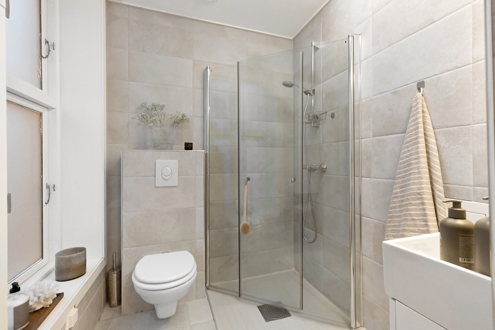 Romslig baderom med flislagte overflater og gulvvarme. Galleribilde