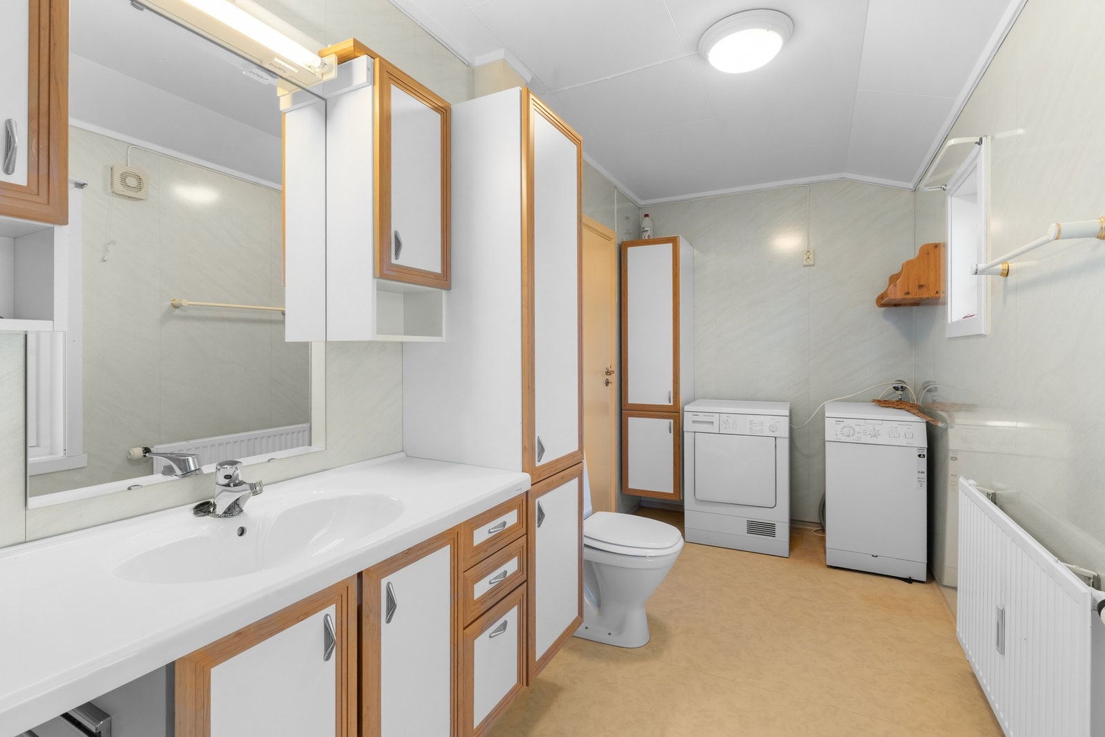 På badet er det både en romslig baderomsinnredning og opplegg for vaskemaskin og tørketrommel Galleribilde