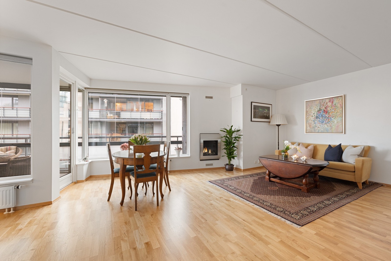 Romslig og lys stue med en sosial, åpen løsning mot kjøkkenet, som gir gode soner for både sofa- og spiseplass. Galleribilde