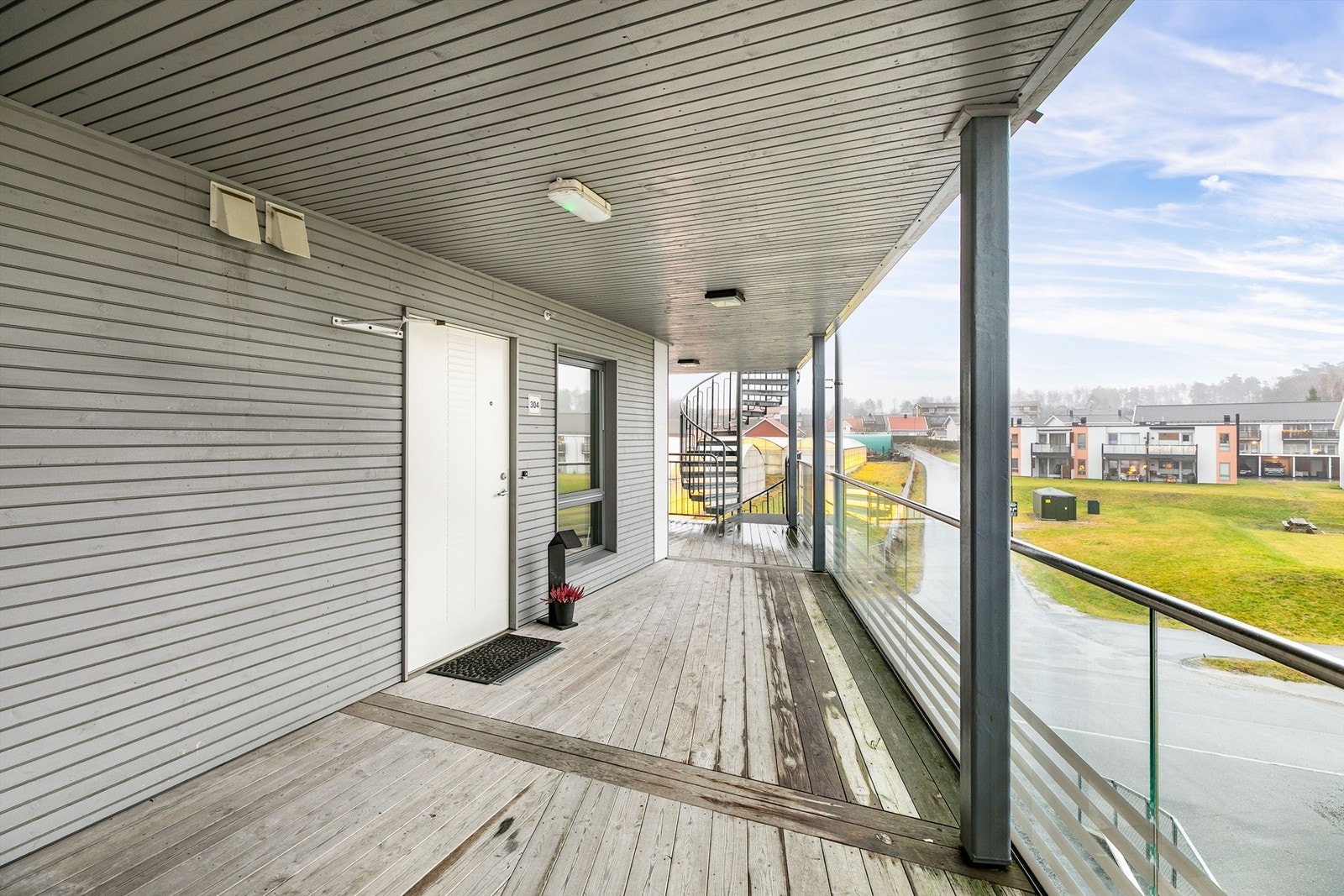 På svalgangen foran inngangsdøren er det sol tidlig på dagen sommerstid og rom for en liten sittegruppe. Galleribilde