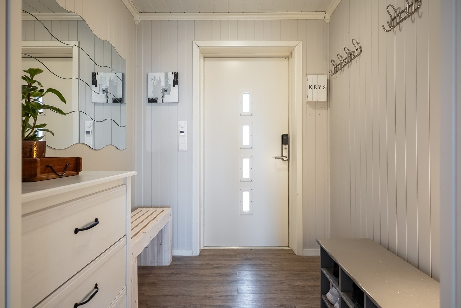 Boligens entrè har god plass til å henge fra seg både yttertøy og sko. Her er det også etablert varmekabler i gulv. Galleribilde