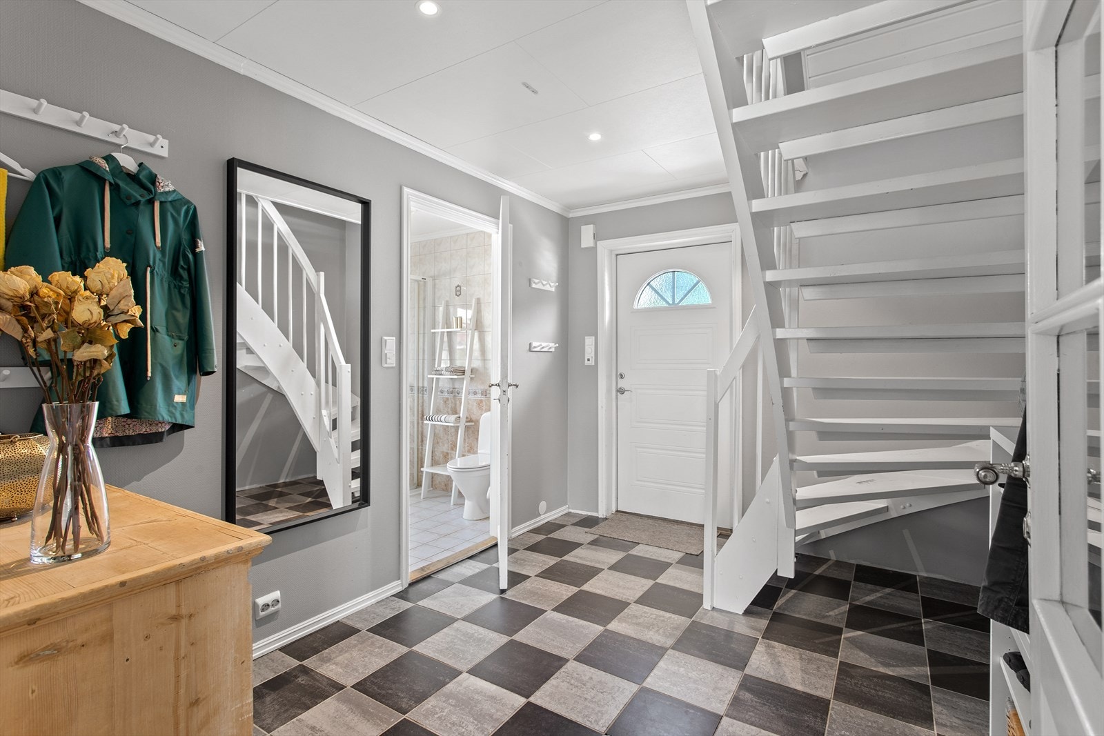 Man ønskes velkommen inn i en lys og romslig gang med trapp opp til 2. etasje. Downlights i tak og varmekabler i gulvet. Galleribilde