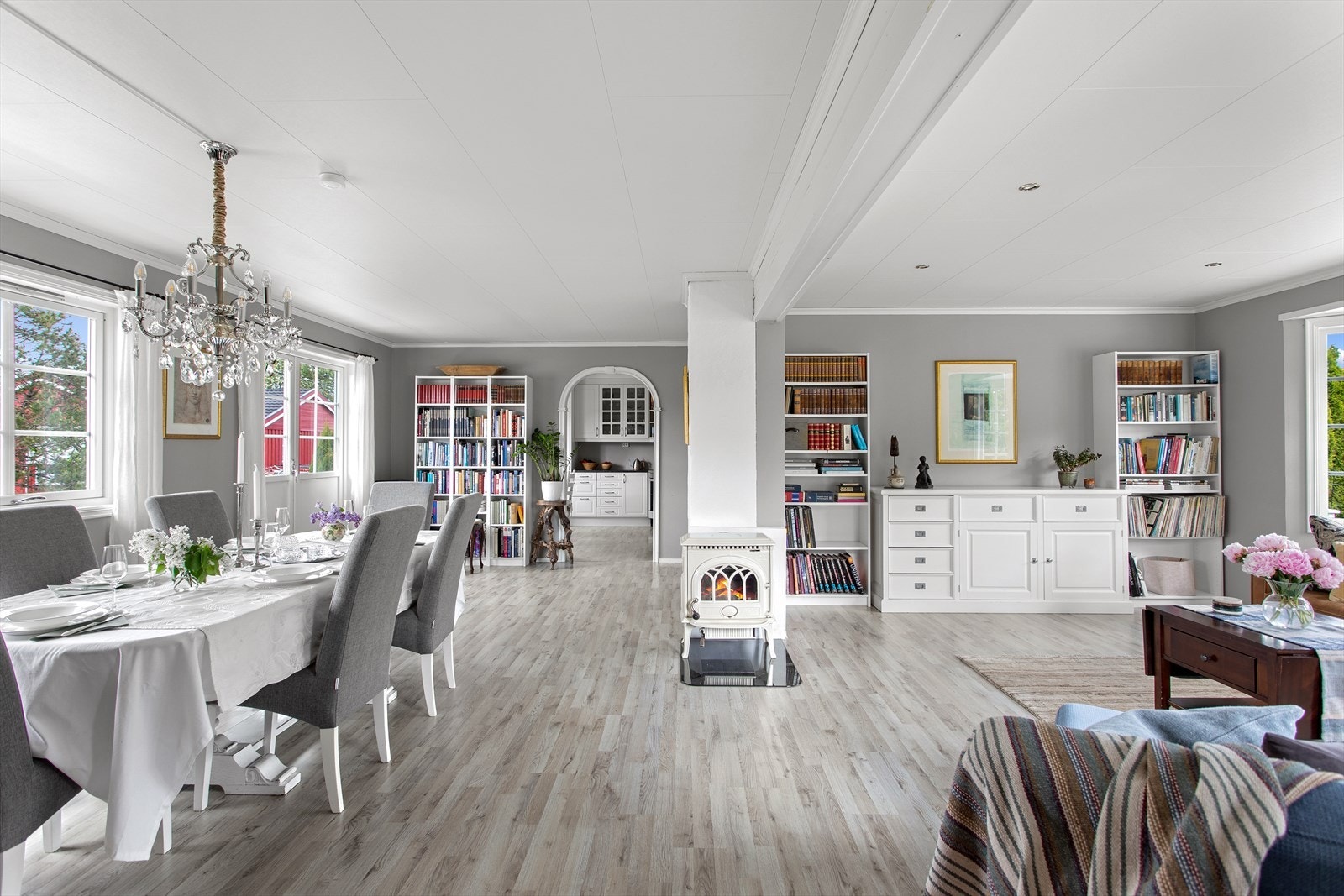 Midt i rommet er det satt inn en flott og hvitlakkert støpejerns-vedovn som varmer godt på kaldere dager. Galleribilde