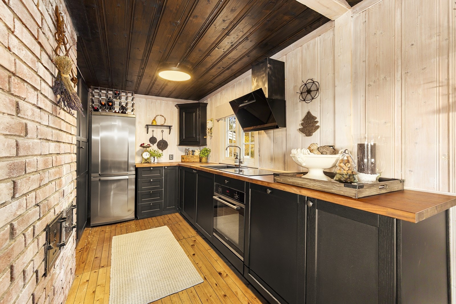 Kjøkkenet har innredning med profilerte fronter. Benkeplaten er av laminat. Det er kjøl/fryseskap, oppvaskmaskin, induksjonstopp og stekeovn. Kjøkkenventilator med avtrekk ut Galleribilde