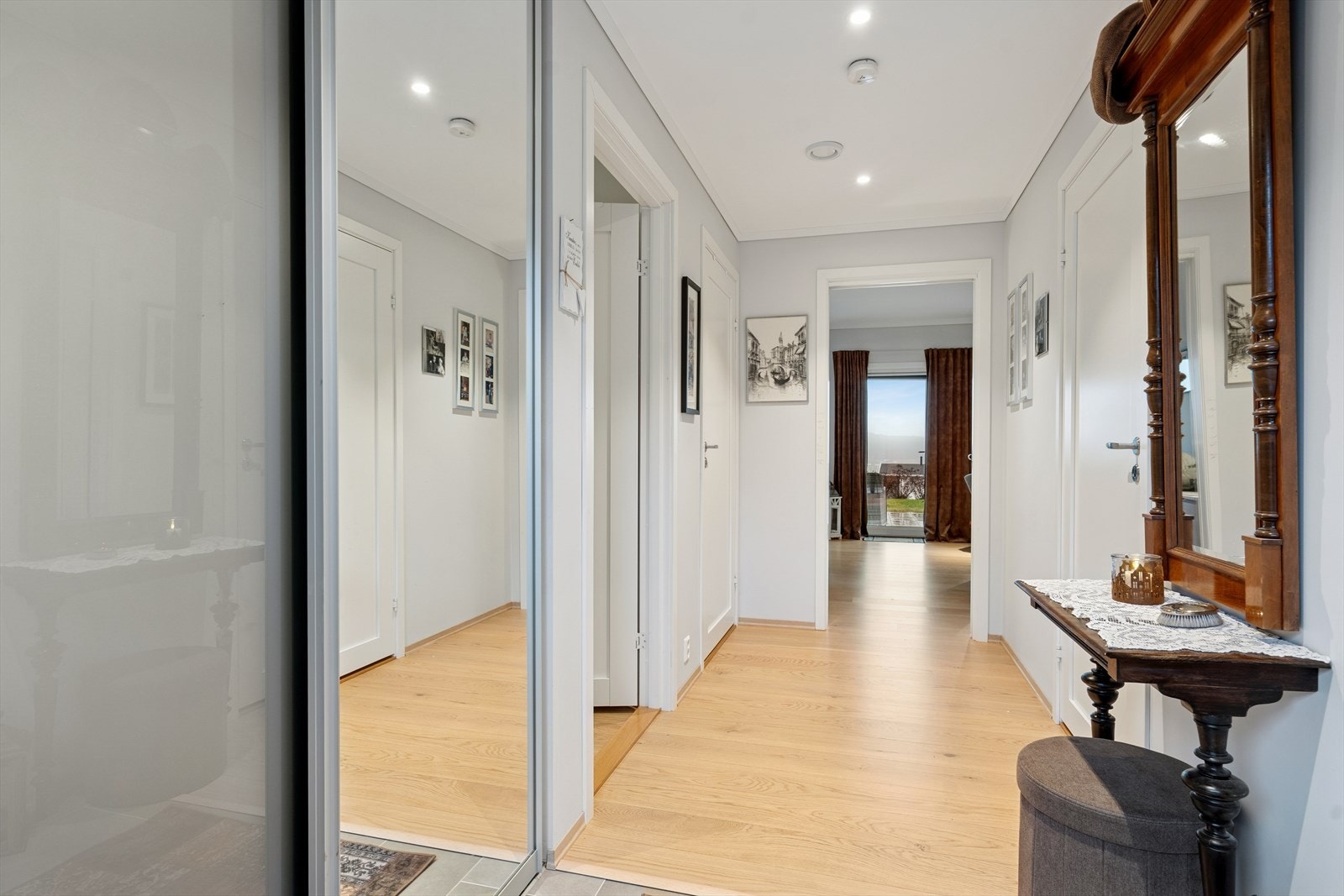 Velkommen inn - lys og luftig gang med moderne uttrykk. Plass for ekstra oppbevaring i skyvedørsgarderobe. Galleribilde