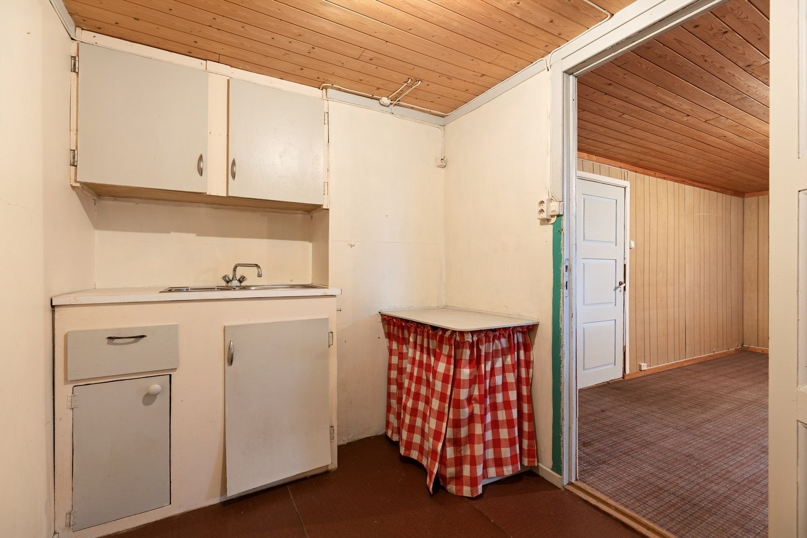 Kjøkken - Ikke søkt godkjent. Eldre og enklere kjøkkeninnredning. Rommet fremstår med som en bod hvor det er satt inn vask. Galleribilde