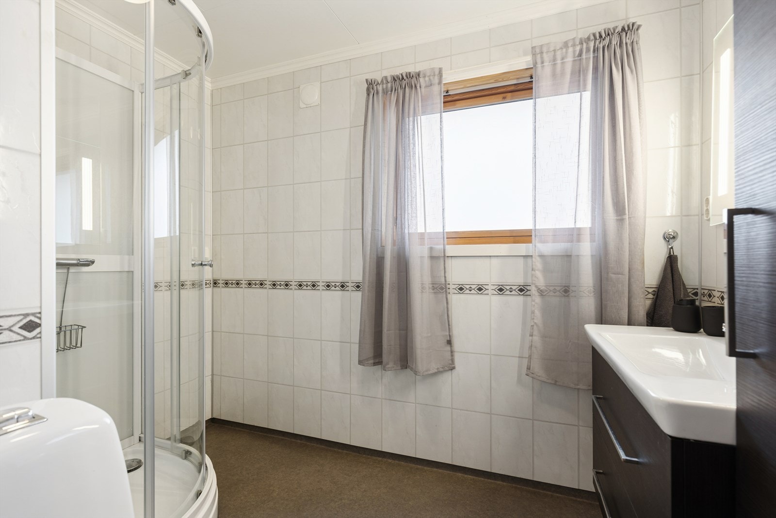 Modernisert bad på ukjent tidspunkt. Det foreligger ingen dokumentasjon. Veggene har baderomsplater. Taket har himlingsplater. Gulvet har vinylbelegg. Rommet har dusjkabinett, servant med møbel og toalett. Naturlig ventilering. (TG3 i rapporten). Galleribilde