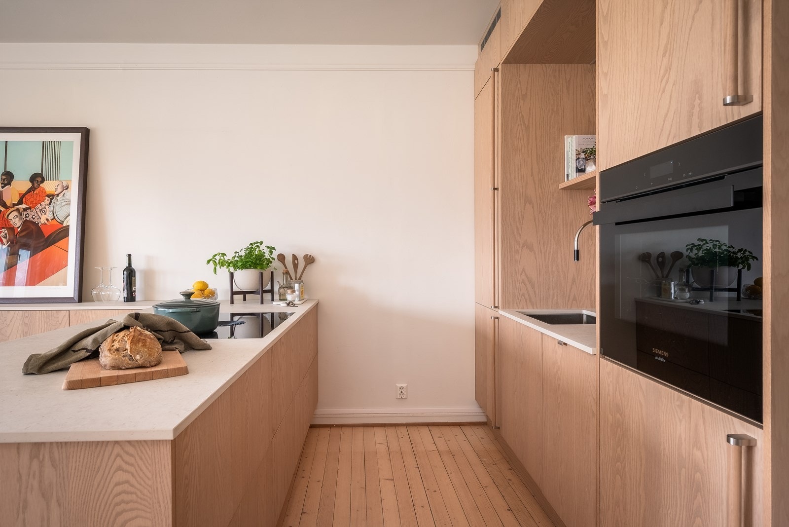 Den praktiske ekstra benken/øyen gir godt med ekstra oppbevaringsplass. I skapet under stekeovnen finner du vaskemaskin med tørketrommel. Galleribilde