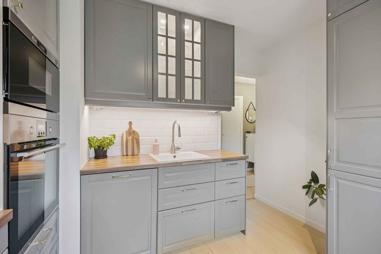 Kjøkkeninnredning med grå, profilerte fronter og benkeplate i heltre. Galleribilde