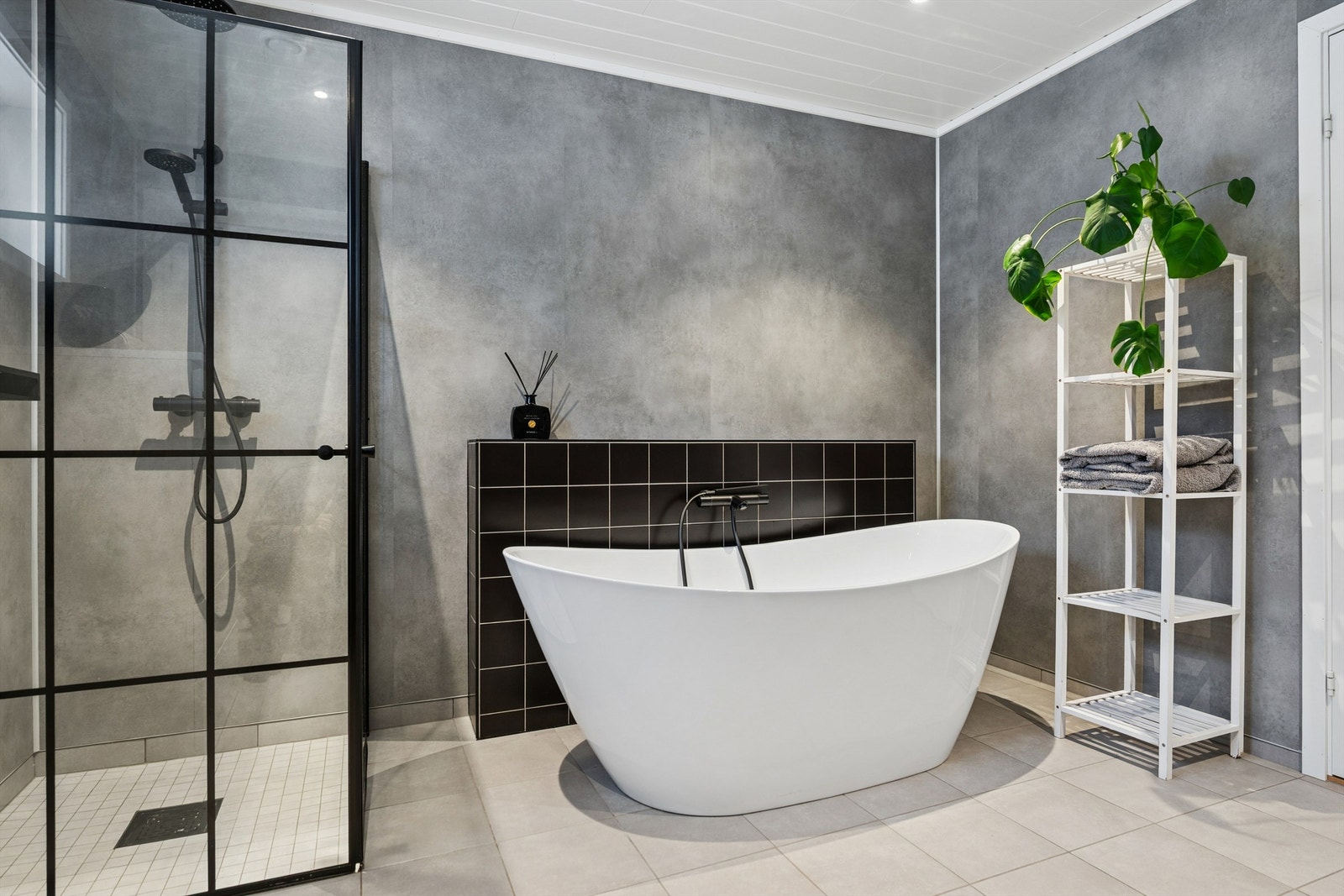 Det lekre moderne badet er utstyrt med både et dusjhjørne med glassdører og et frittstående badekar. Galleribilde