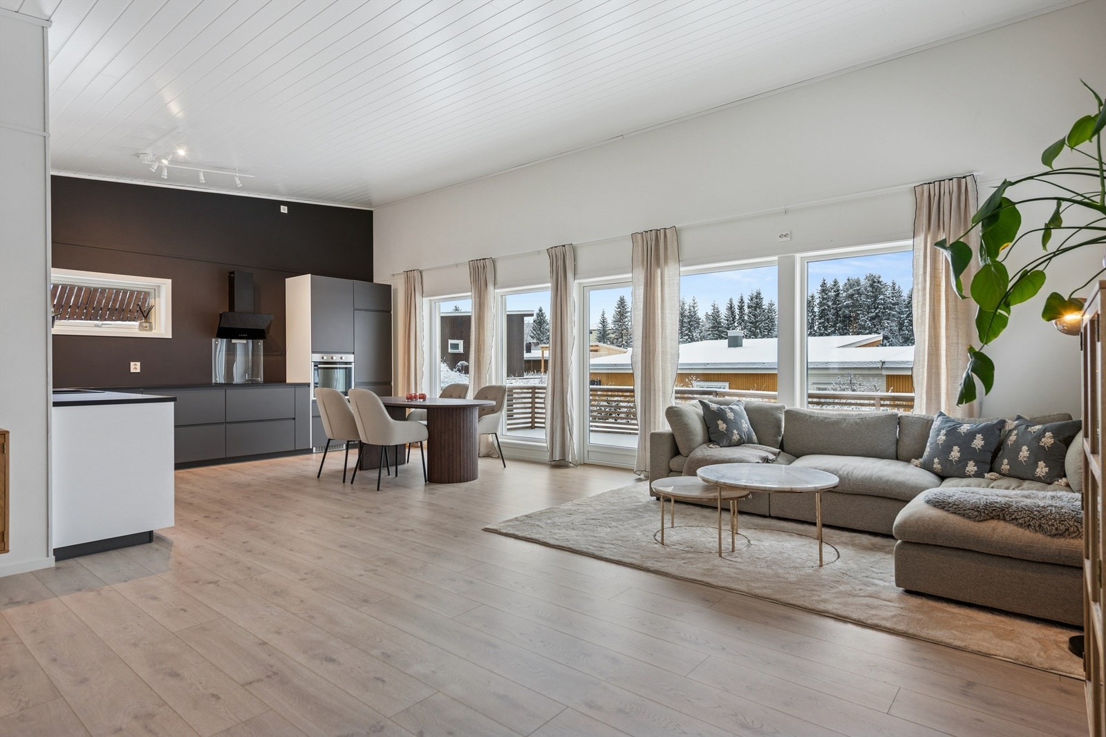 Stue og kjøkken i åpen løsning utgjør boligens sosiale samlingspunkt. God takhøyde gir rommet et luftig preg. Galleribilde