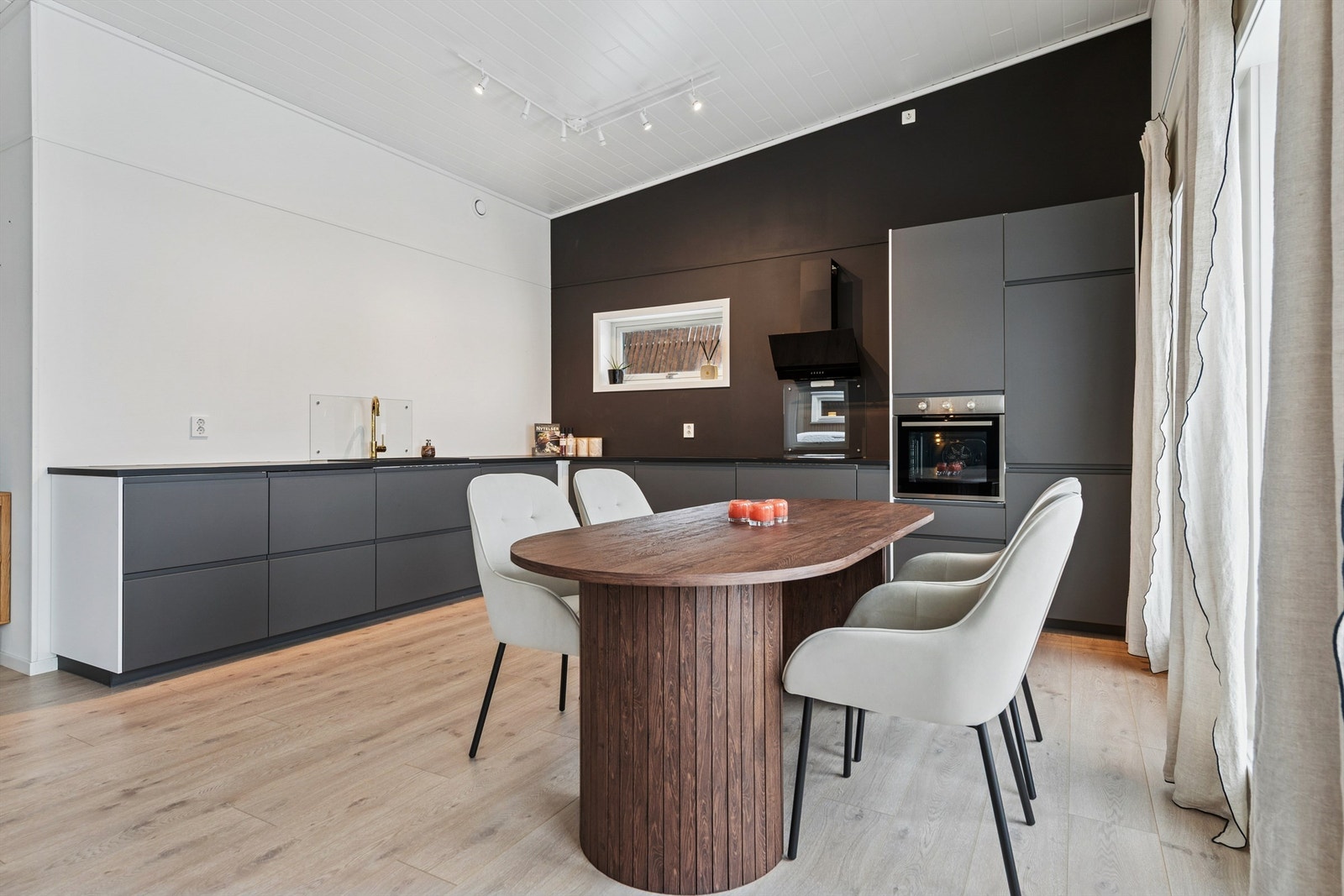 Stilrent moderne kjøkken med mørke, slette fronter og integrerte hvitevarer. Galleribilde