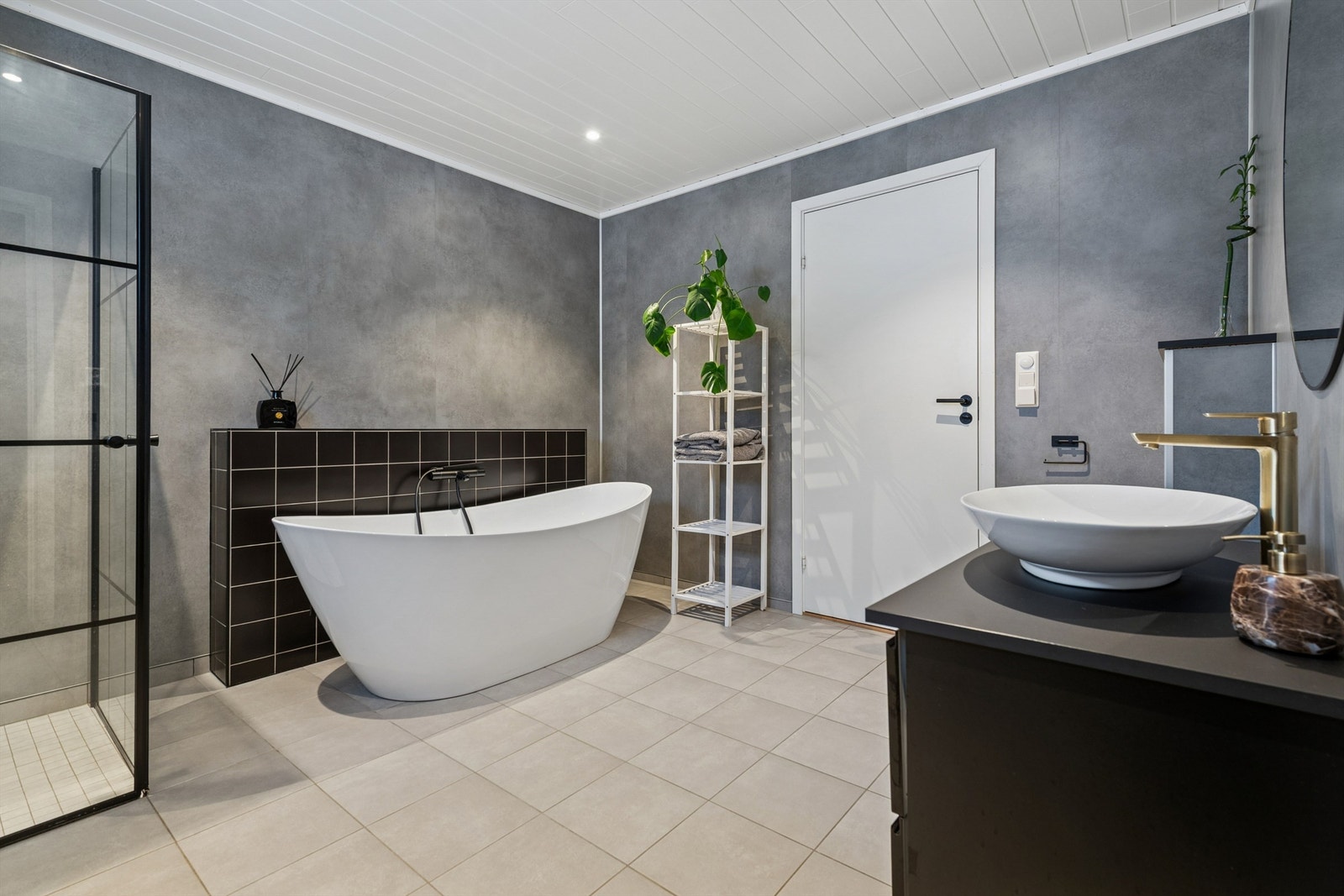 Rommet har flislagt gulv med behagelig gulvvarme og baderomsplater på veggene. Galleribilde