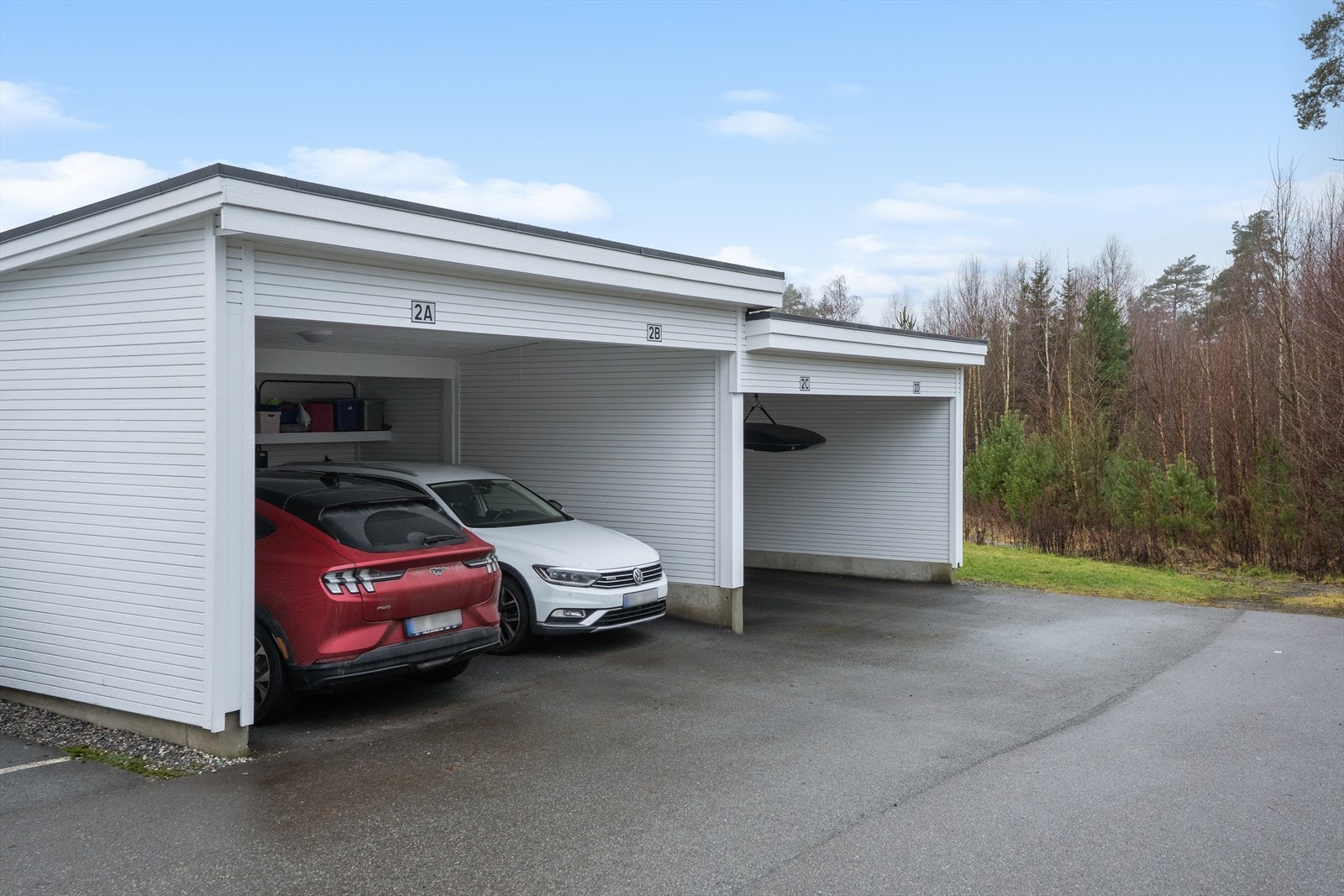 Parkering for én bil i felles carportrekke. El-bil lader er montert. Galleribilde