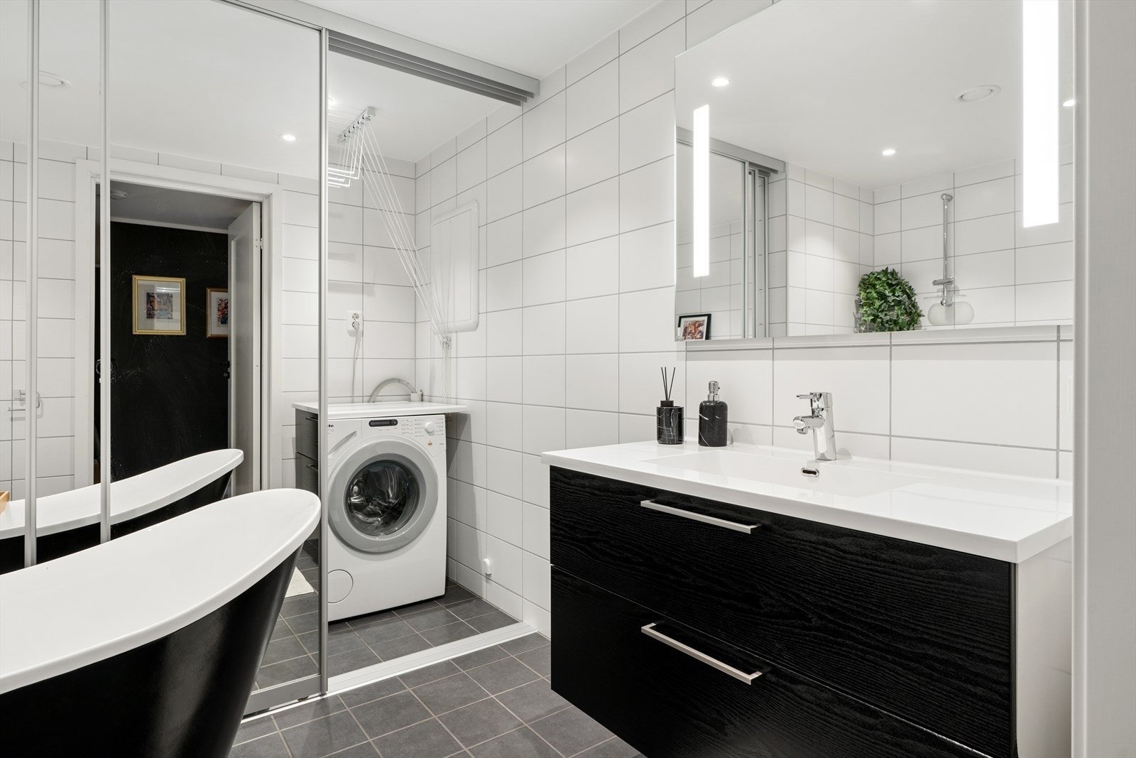 Baderomsinnredningen er utstyrt med servant og bl. batteri, speil, lys, dusjhjørne med badekar og vegghengt toalett. Vaskeromdel utstyrt med laminat benkeplate, opplegg for vaskemaskin. Galleribilde