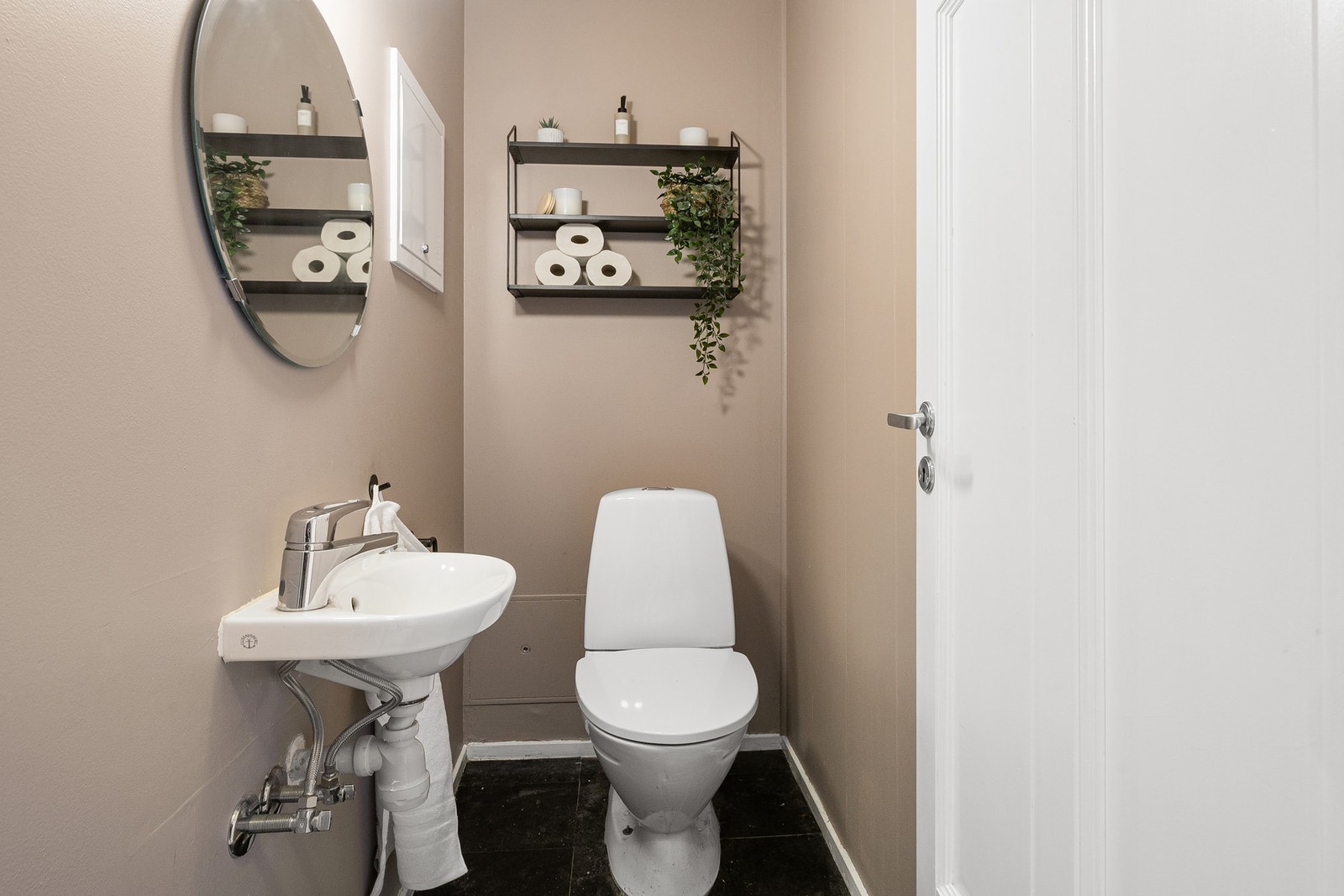 Vegg i vegg med badet er toalettrommet med vask. Galleribilde