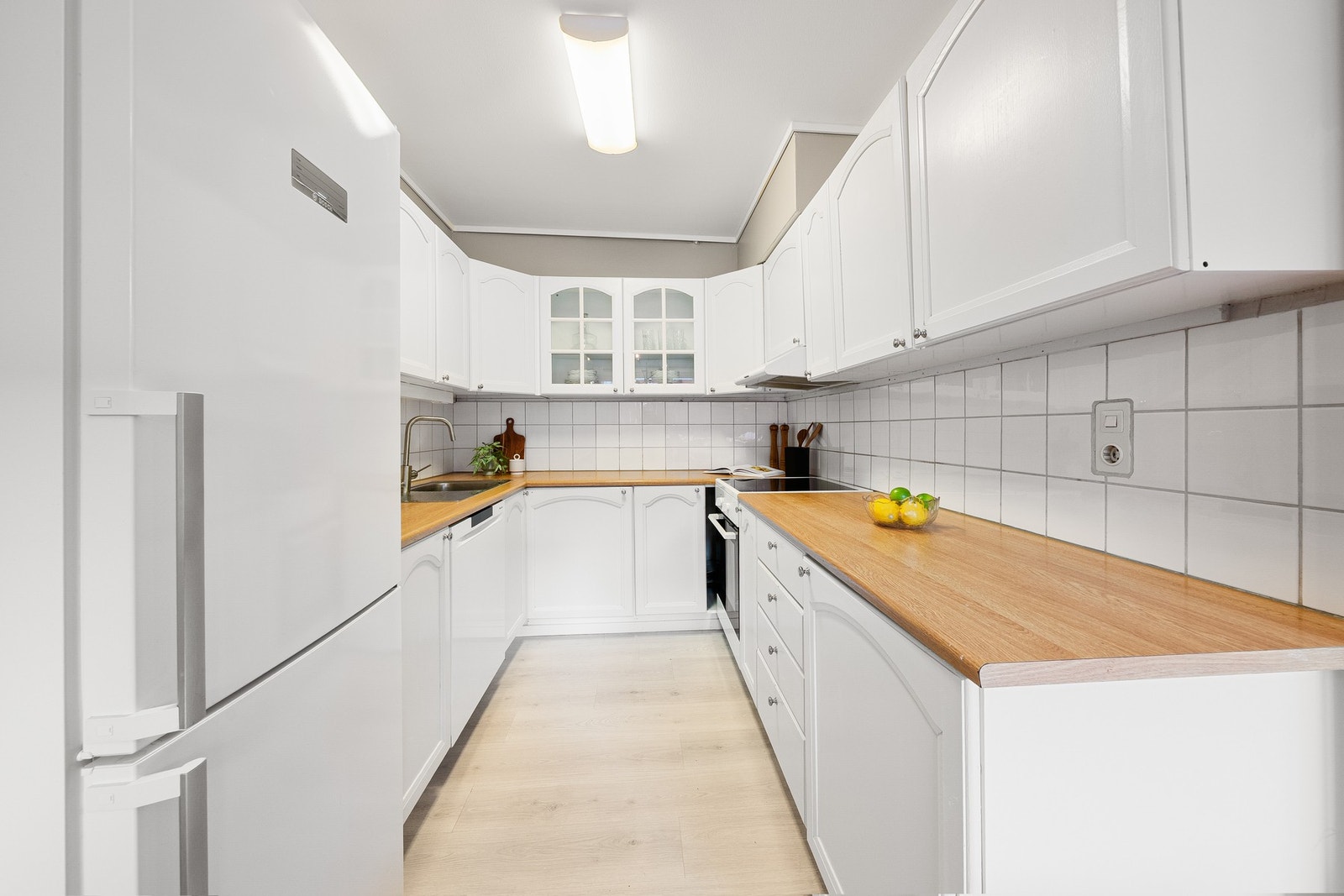 Lyst kjøkken utstyrt med frittstående hvitevarer. Galleribilde