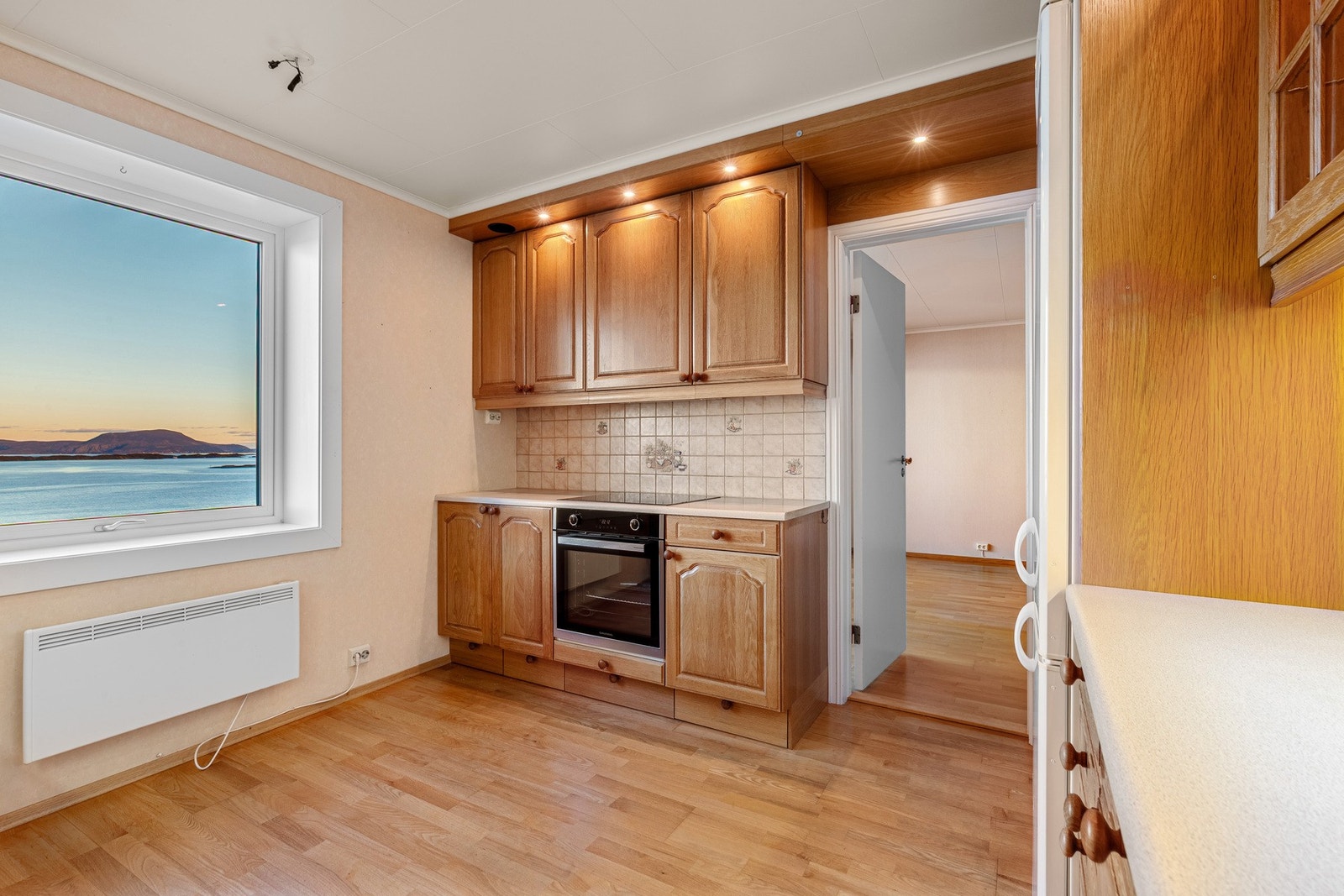 Kjøkkenet har innredning med profilerte fronter. Benkeplaten er av laminat med nedfelt vask. Galleribilde