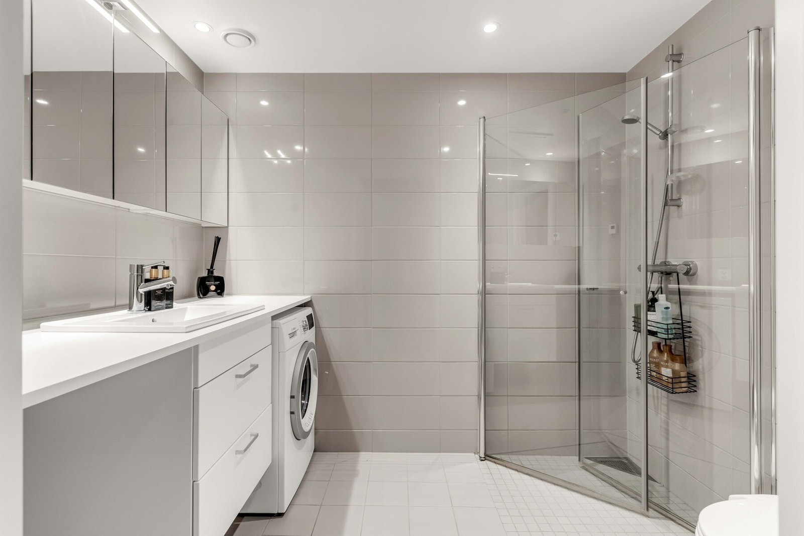 Delikat baderom fra byggeåret 2021 med lyse flislagte overflater og behagelig gulvvarme. Galleribilde