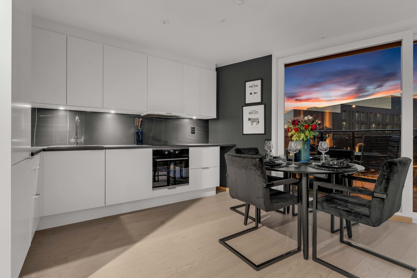 Den åpne løsningen mot kjøkkenet skaper en sosial og innbydende atmosfære, perfekt for både hverdagsliv og hyggelige sammenkomster. Galleribilde