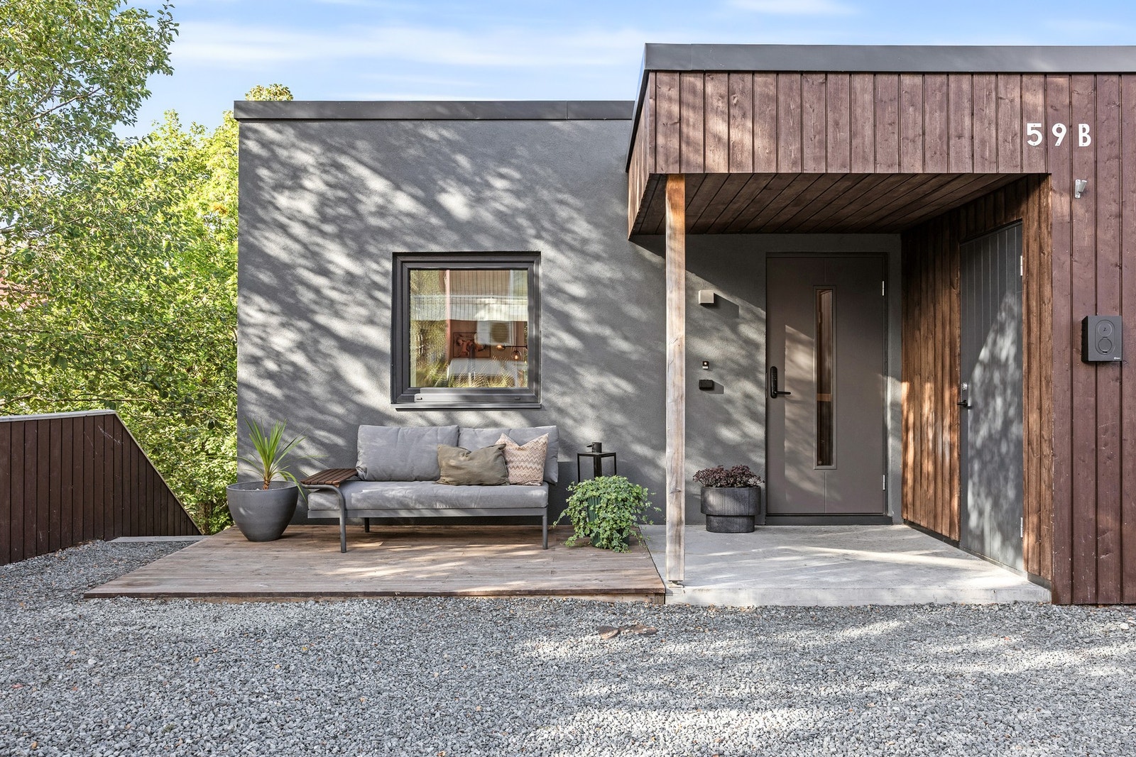 Hyggelig, overbygd inngangsparti med terrasse og tilgang på sportsbod. Det er montert elbillader på veggen. Velkommen inn! Galleribilde