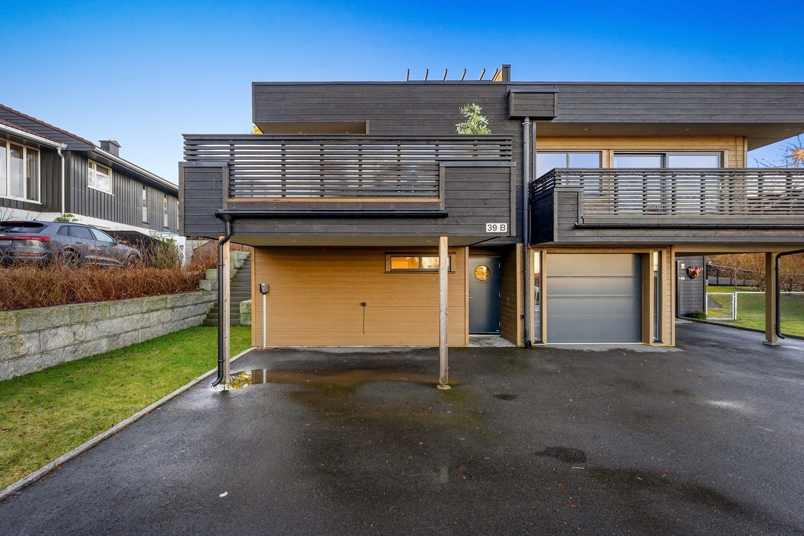 Asfaltert gårdsplass med parkering og el-bil lader. Galleribilde