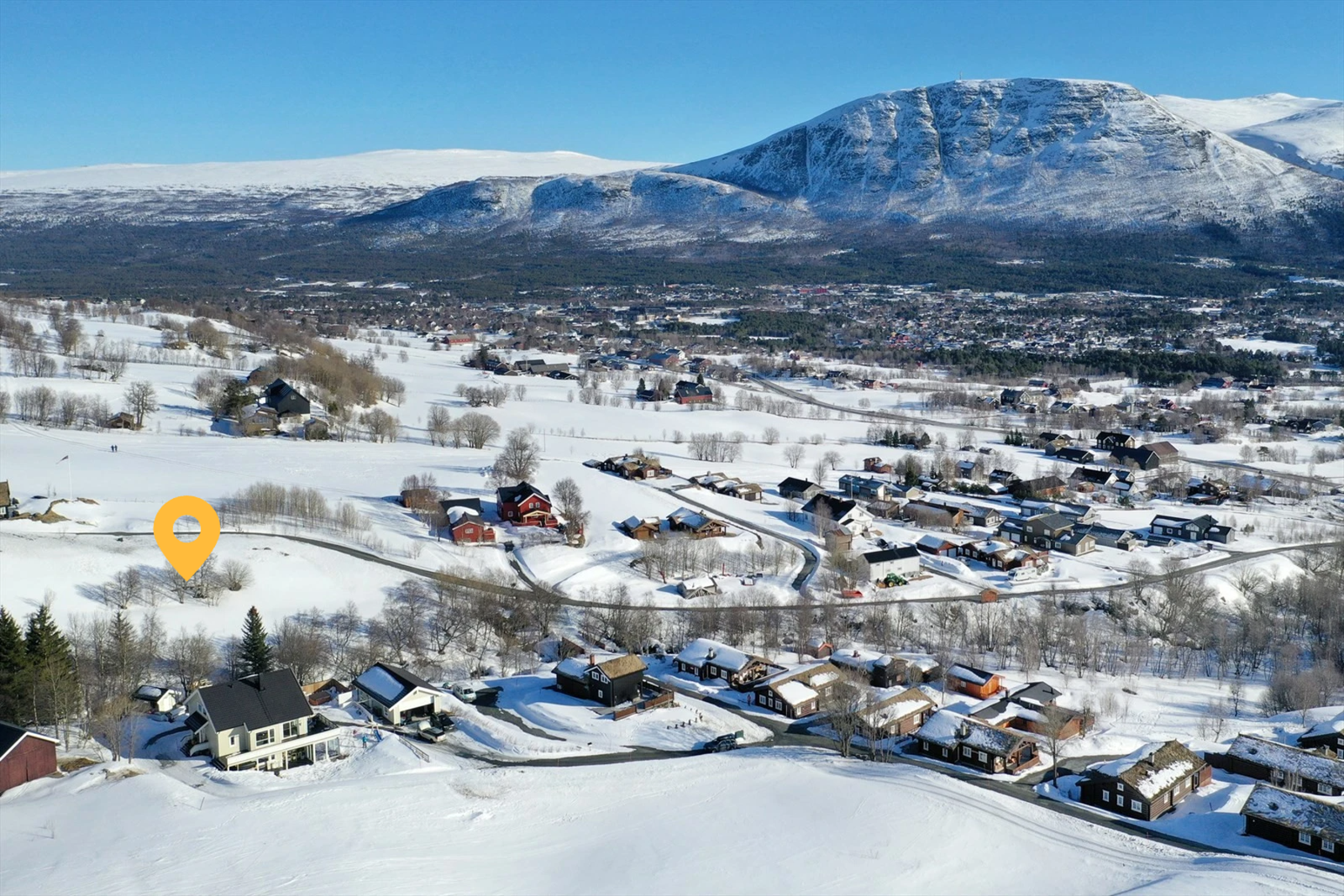 Tomt markert. Dronefoto over tomteområdet og utsikt over bygda Galleribilde