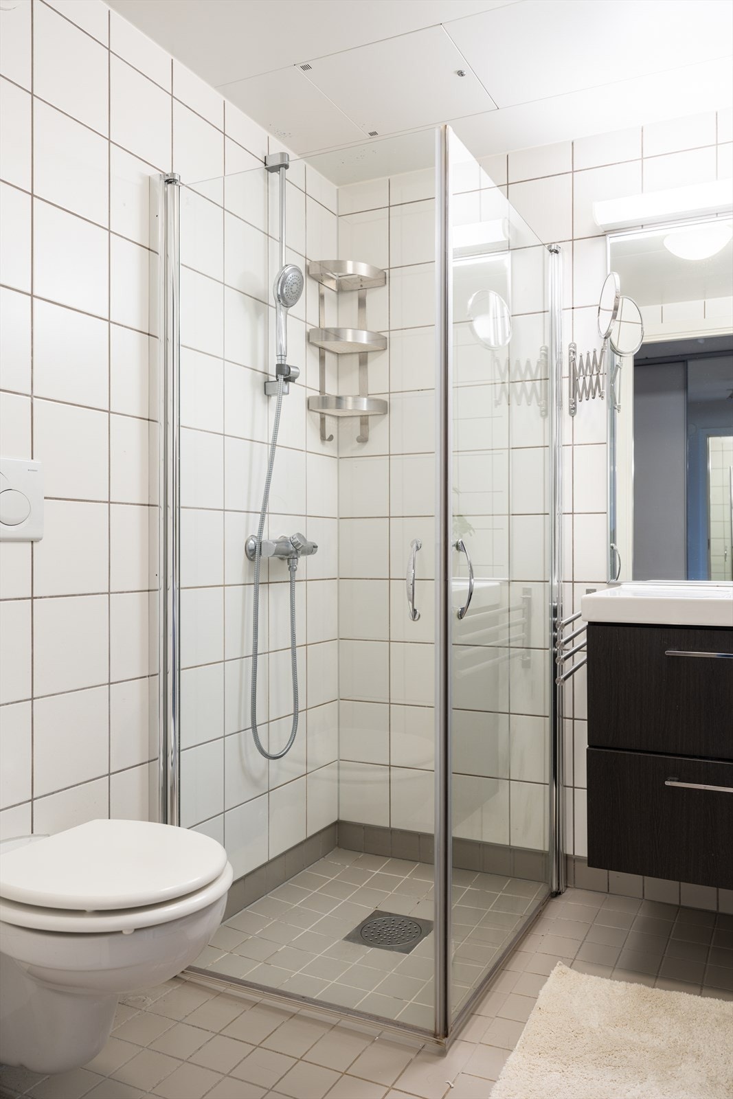 Videre finner du et dusjhørne med svingdører, vegghengt toalett og opplegg for vaskemaskin. Galleribilde