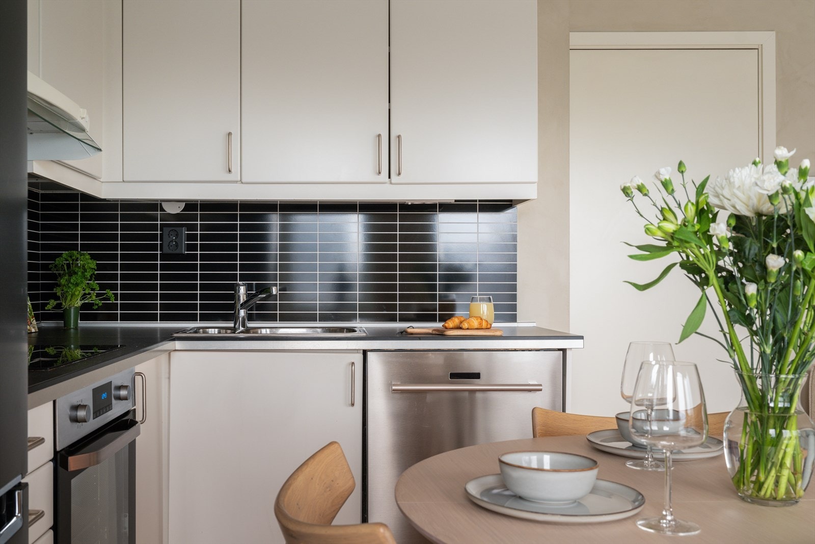 Det er flislignende plater på vegg over benkeplate og belysning via lysstoffrør under overskap. Galleribilde