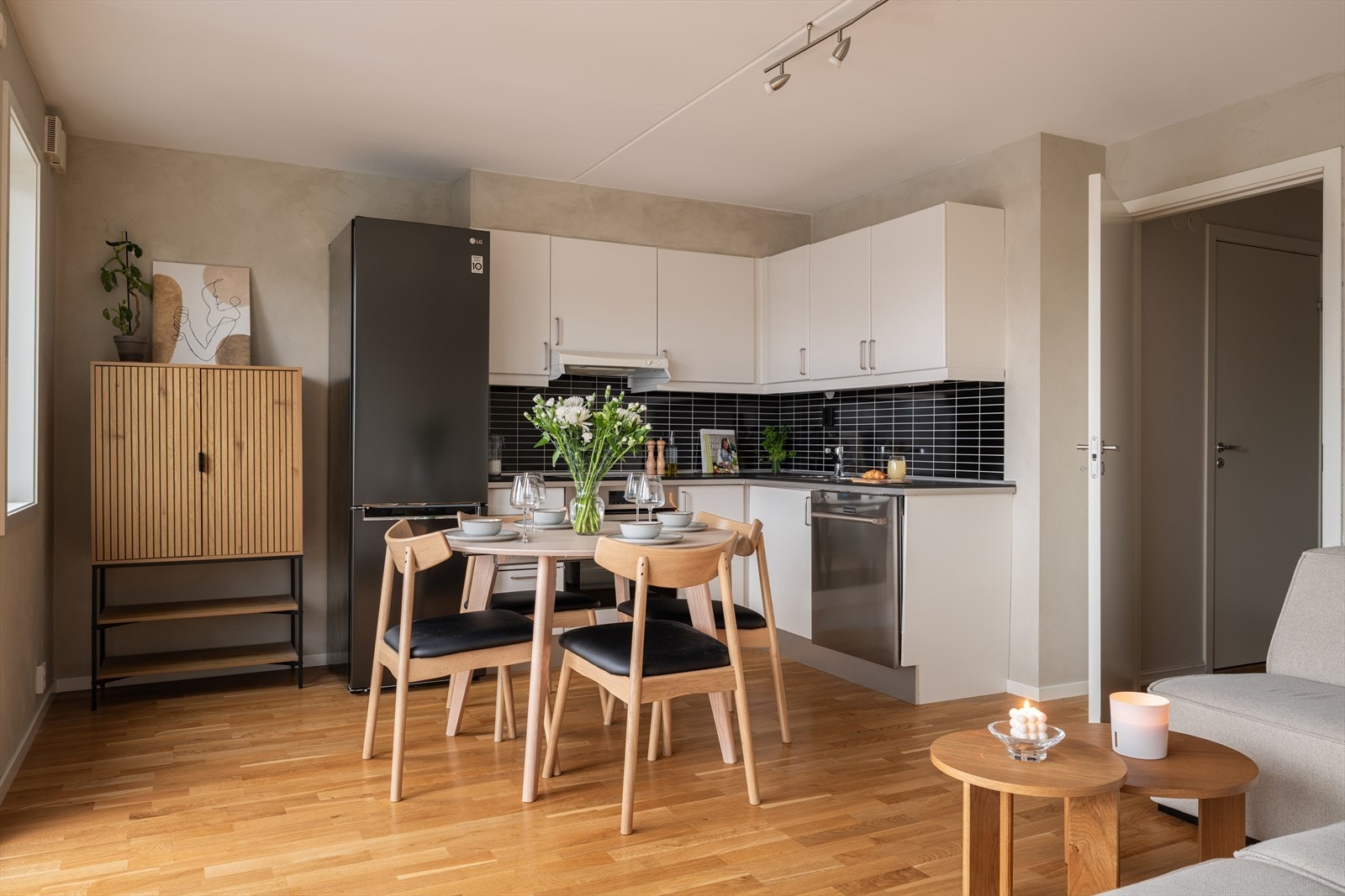 Kjøkkeninnredningen fra Sigdal ligger i en L-form, og har en tidløs og lys innredning med glatte, fabrikklakkerte fronter og laminat benkeplate. Galleribilde