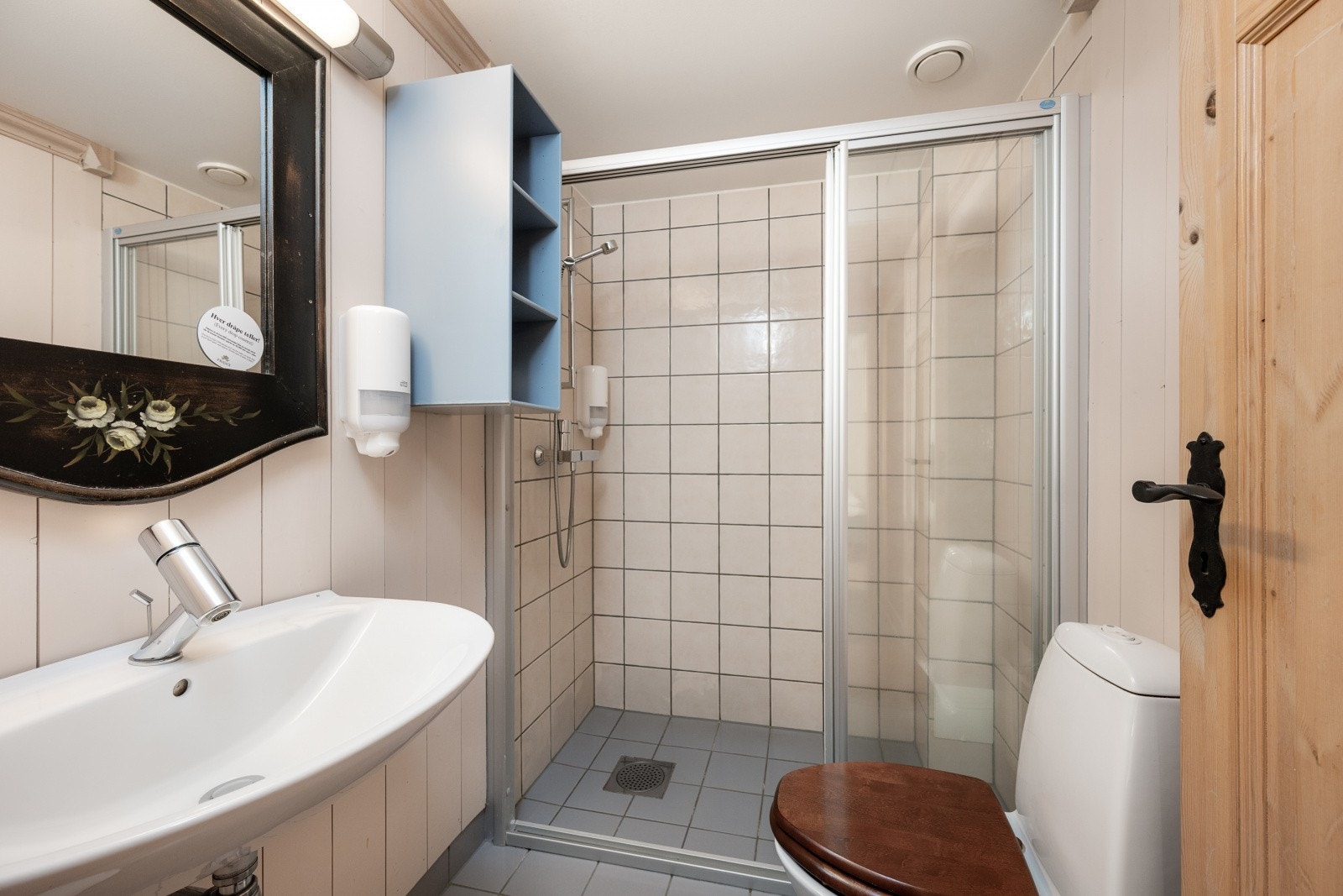 Bad med romslig dusjnisje. Flislagt gulv med varmekabler og fliser/panel på vegger. Galleribilde